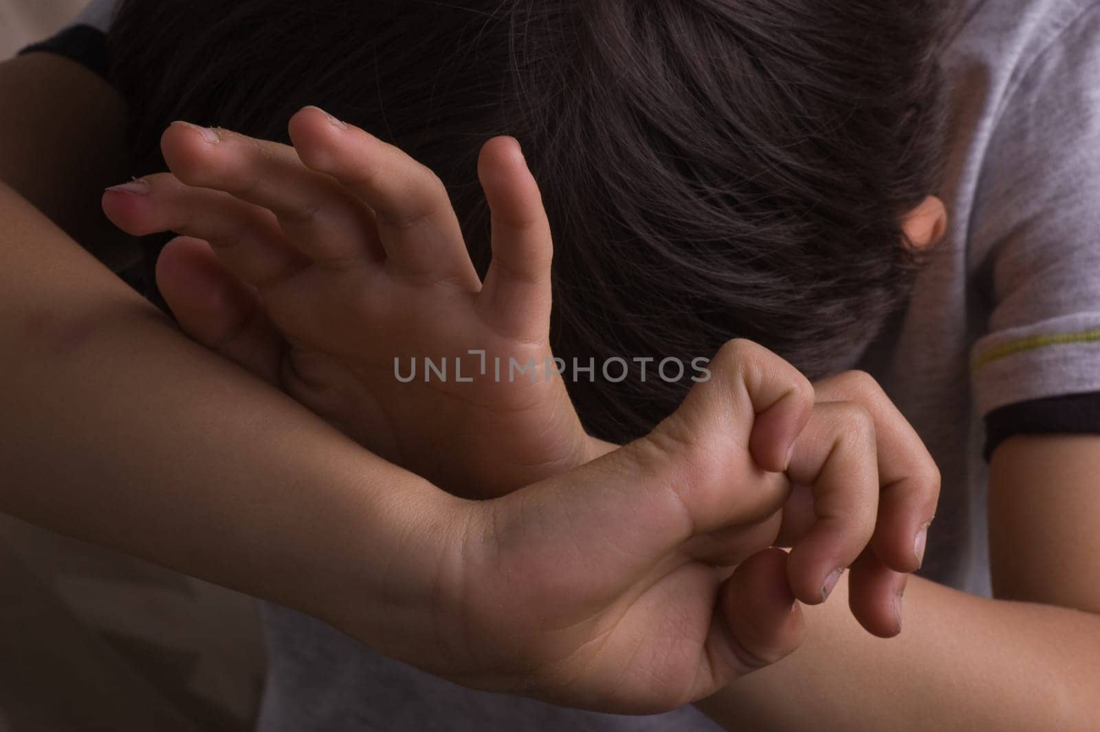 Child raising hands to protect itself
