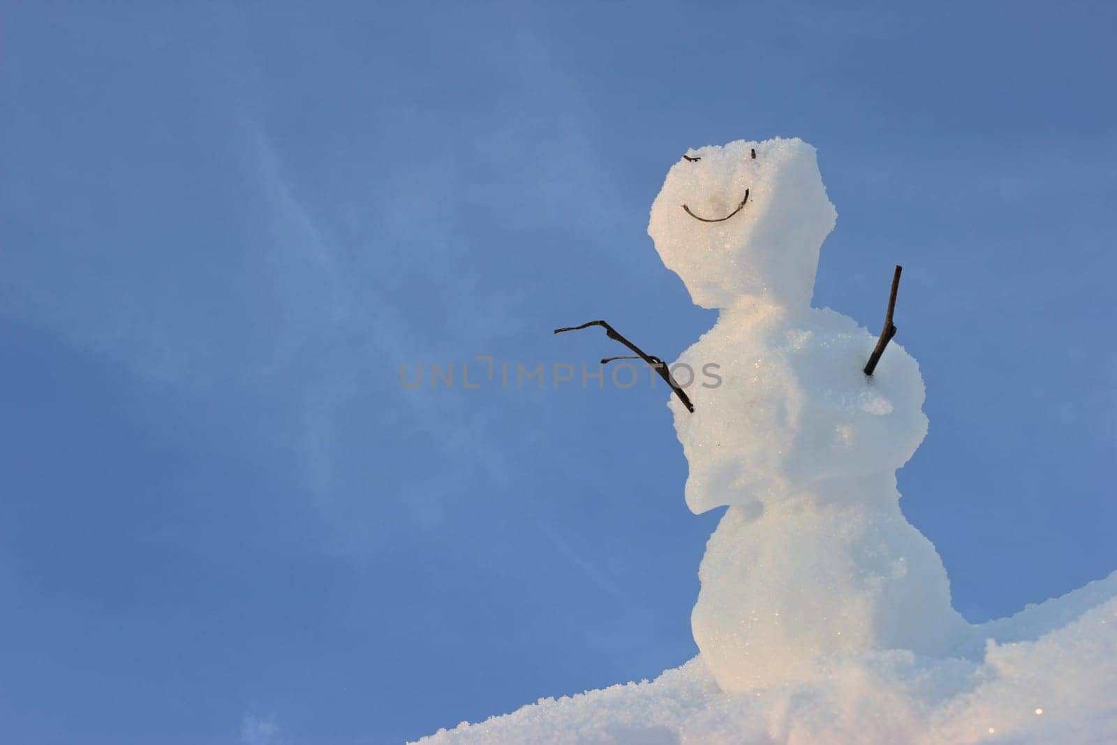Friendly little snowman in front of blue sky
