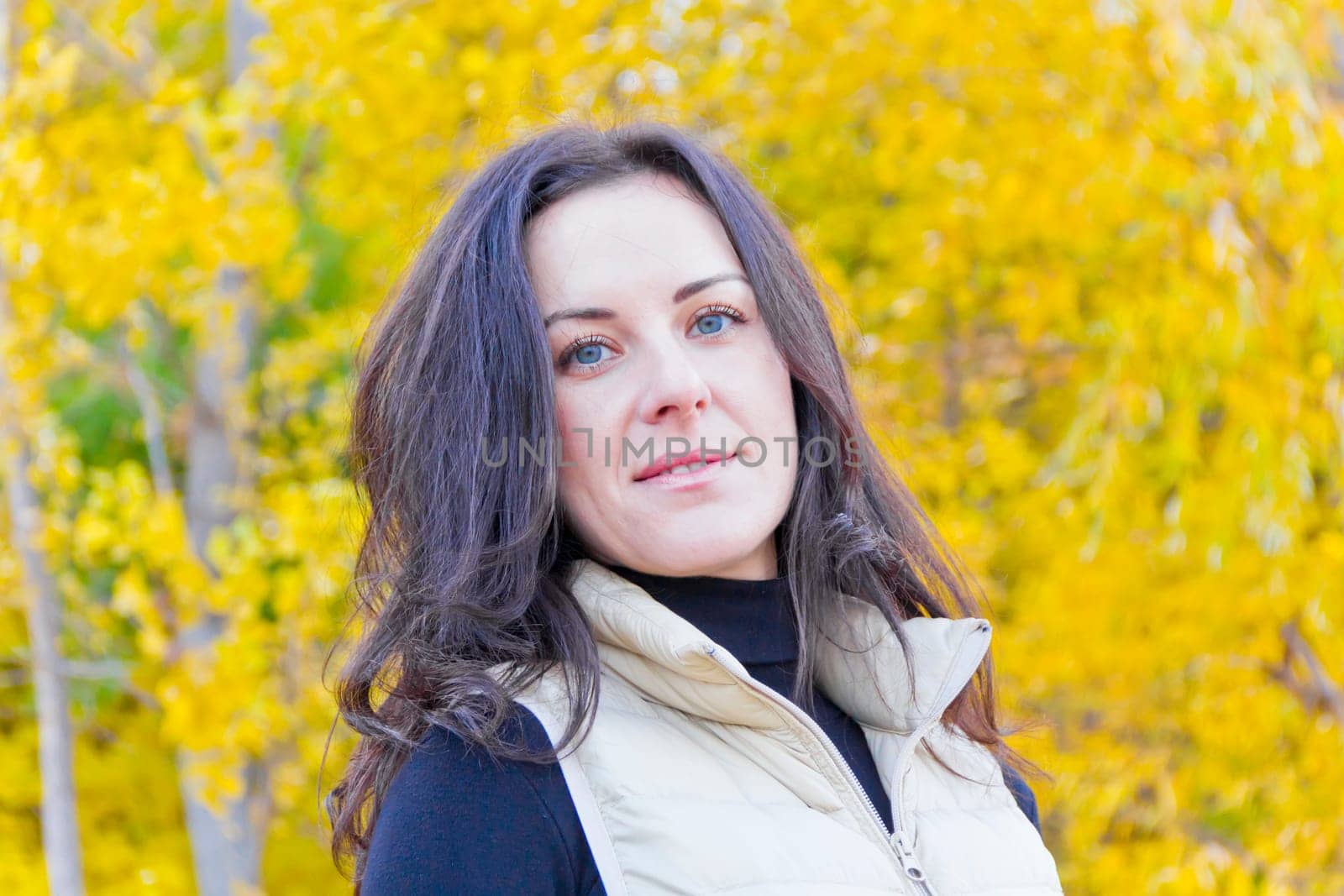 Portrait of beautiful brunette on yellow forest