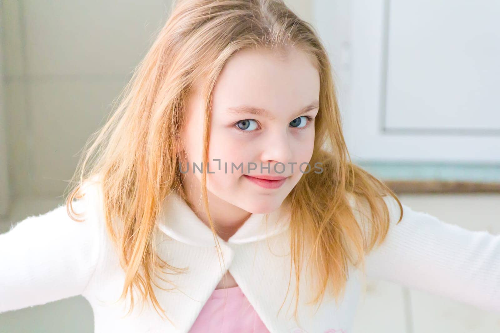 Portrait of cute girl with blond hair in white