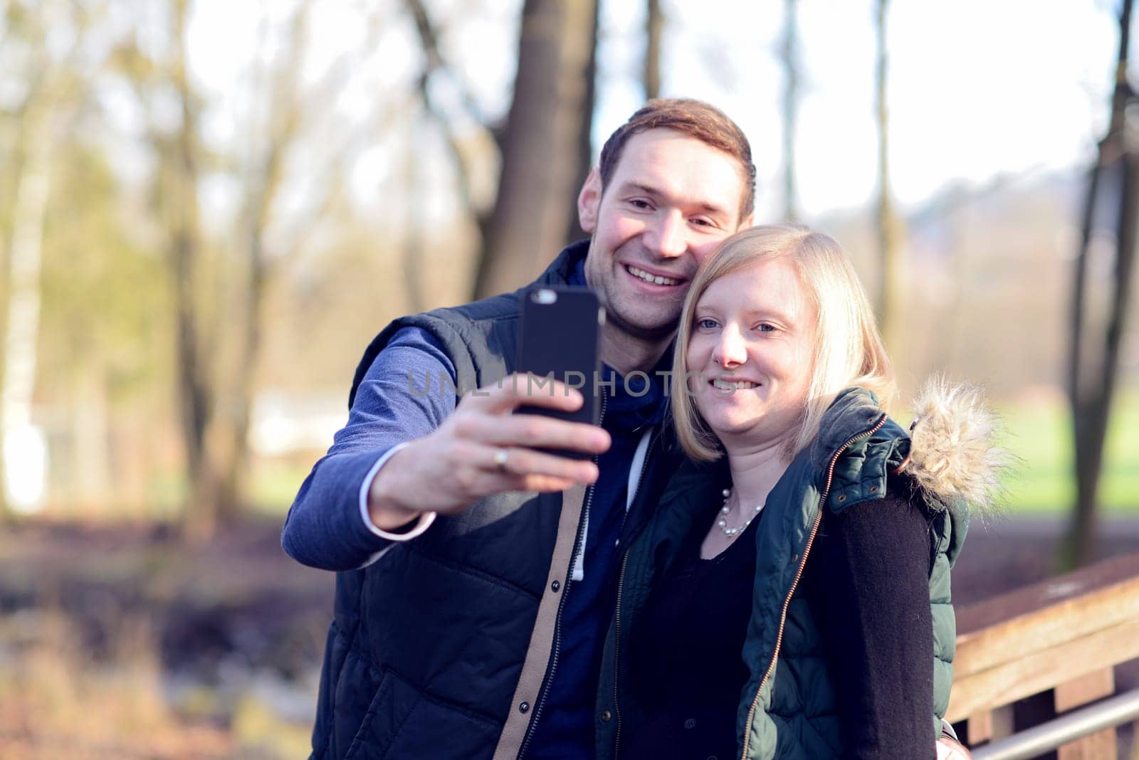 young woman and man in the park taking a sel-portait