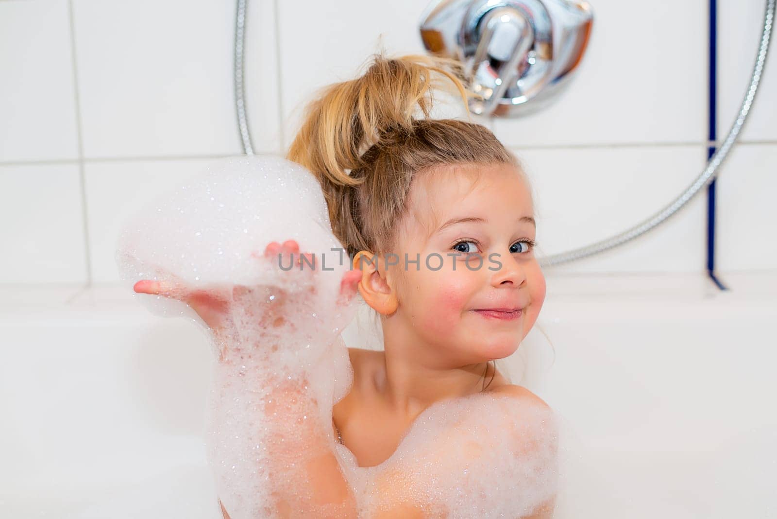 little funny girl with foam bathtub in the bathtub