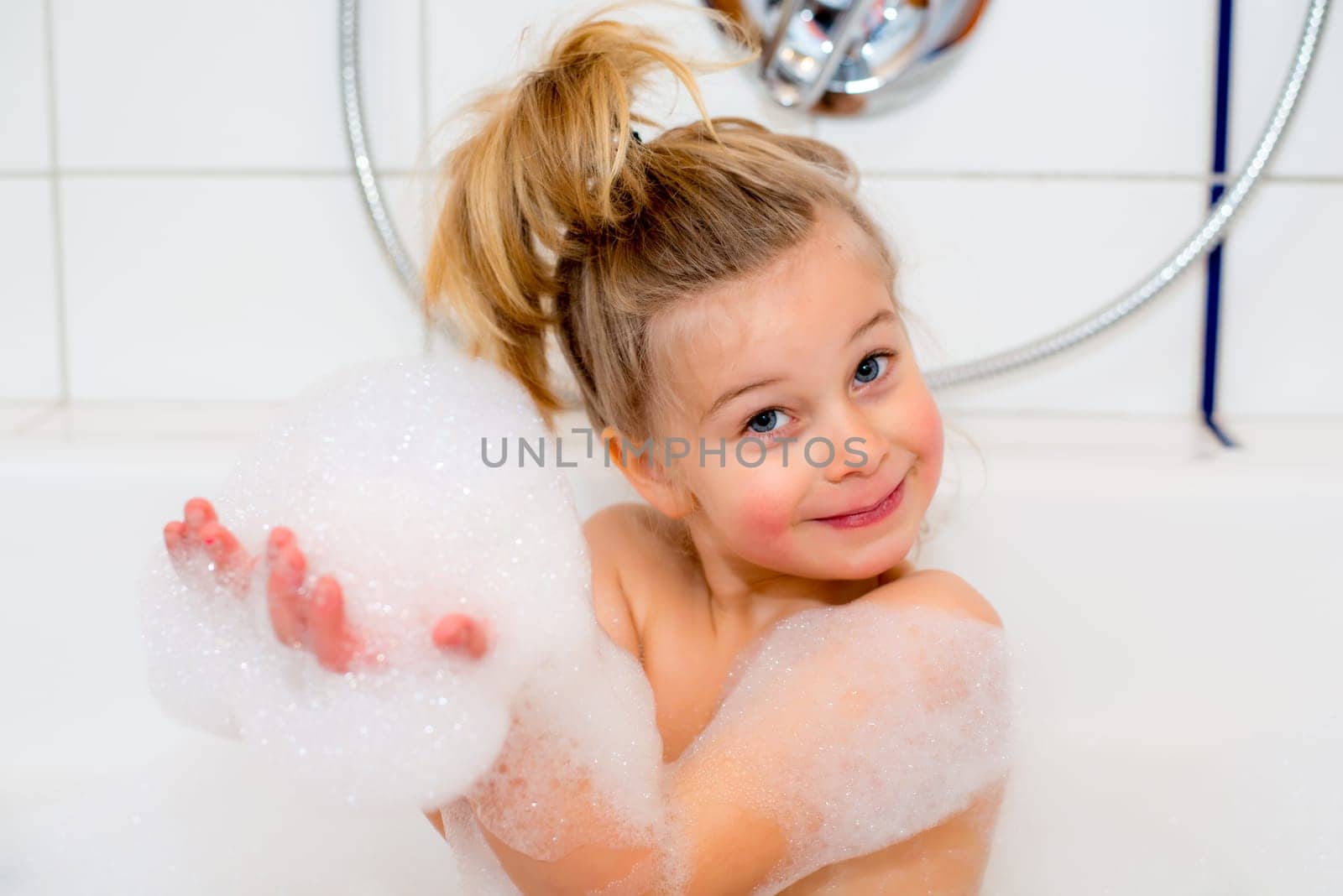 little funny girl with foam bathtub in the bathtub