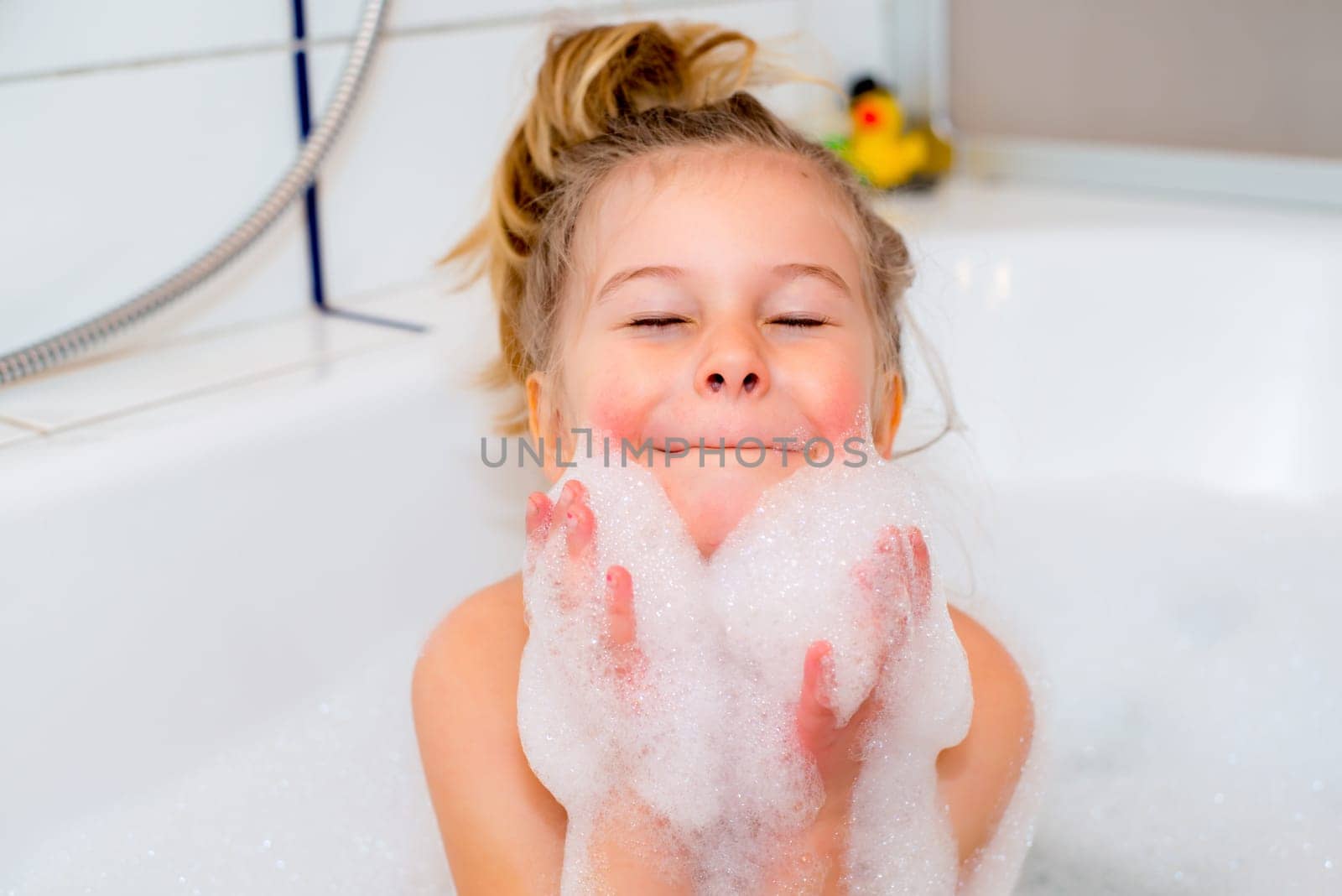 little funny girl with foam bathtub in the bathtub