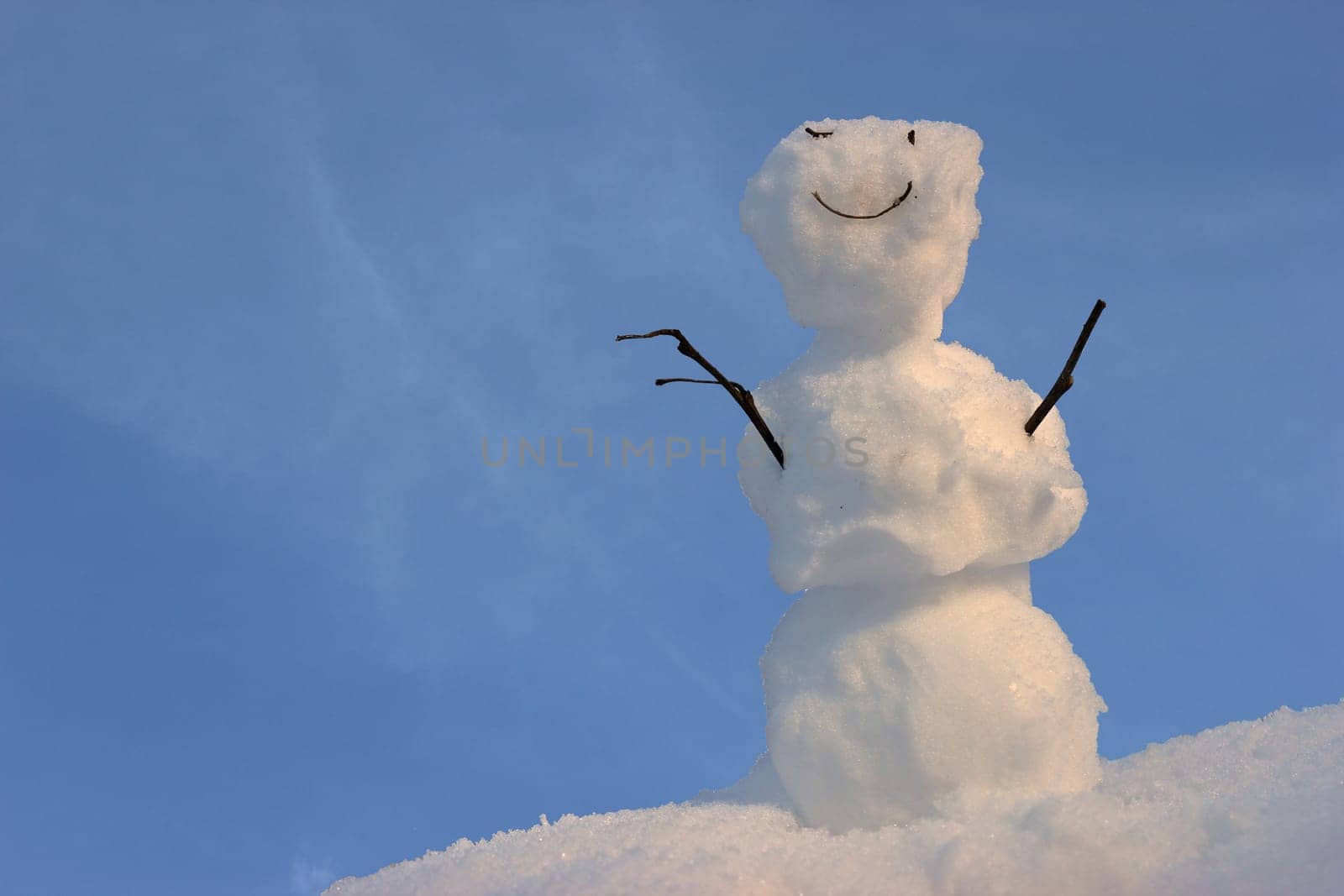 Friendly little snowman in front of blue sky