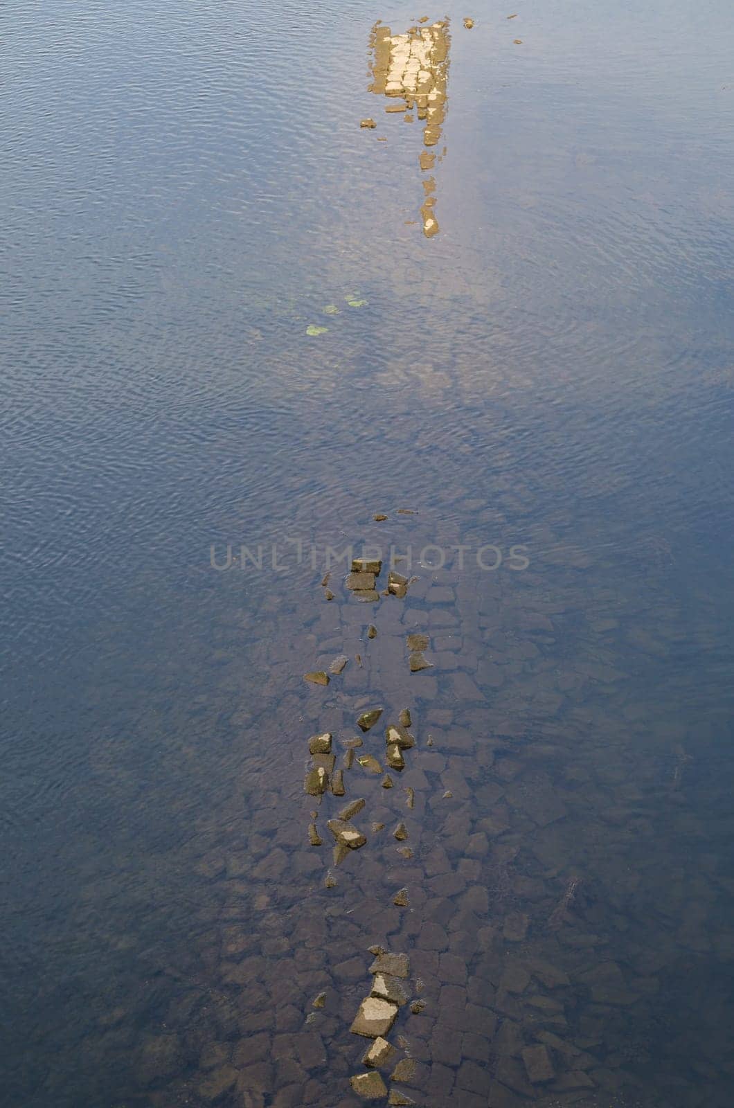 Water surface with sunken wall remnants in the river Ruhr near Hattingen,Germany.