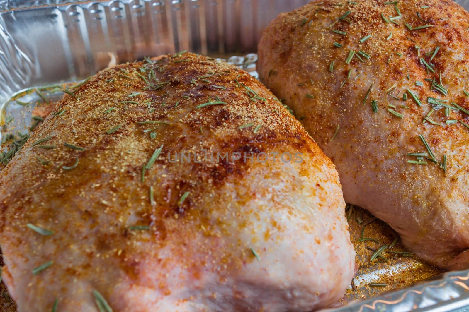 Raw duck breast seasoned in an aluminum bowl.