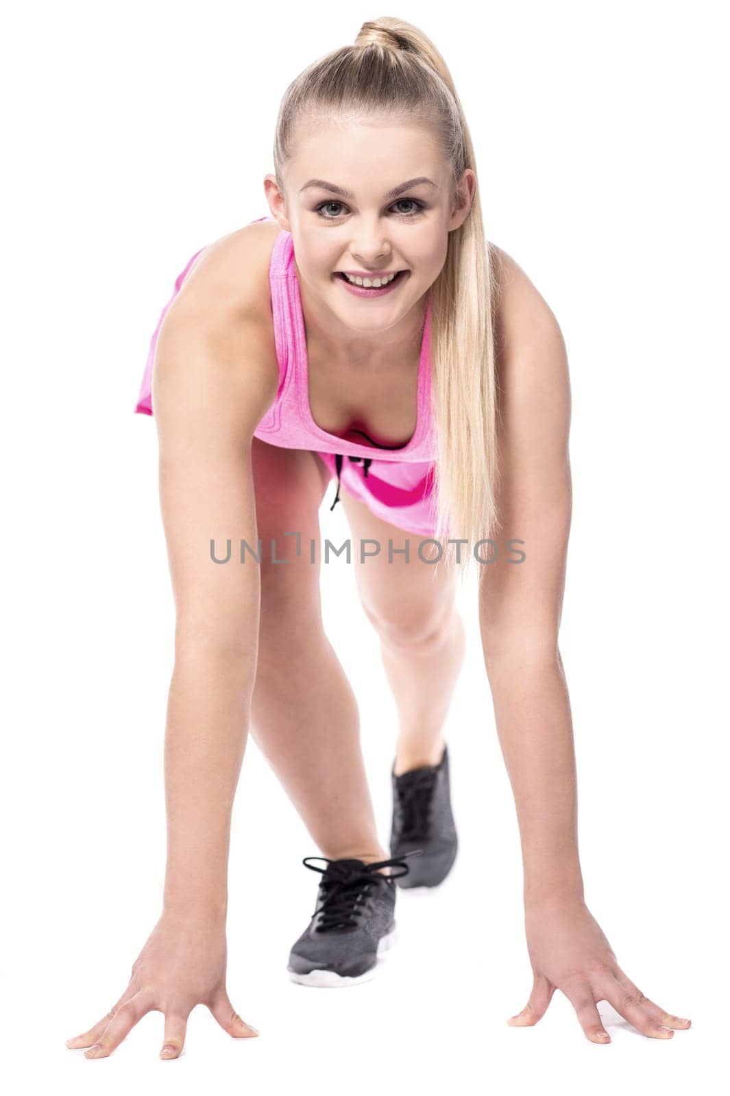 Young female athlete in about to run posture