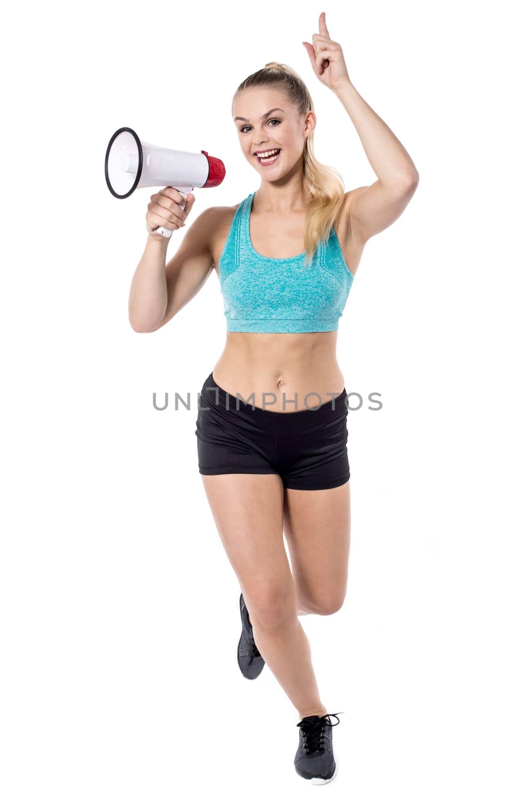 Young woman in sportswear holding megaphone