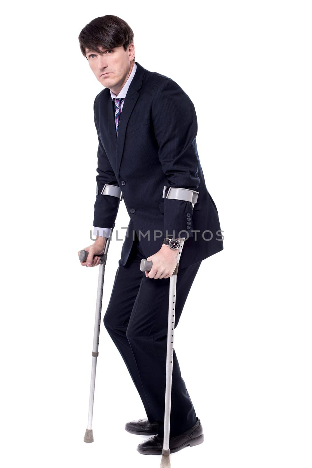 Young businessman posing with his crutches over white