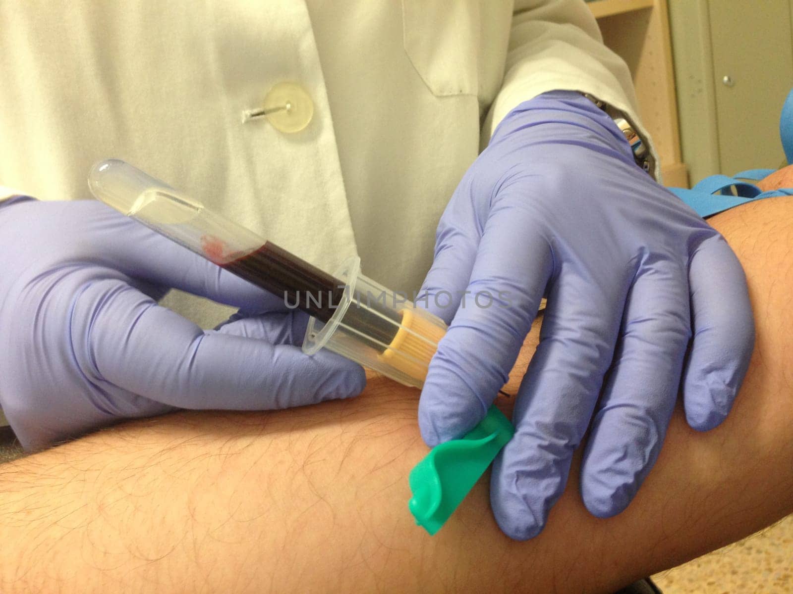 Nurse taking a blood sample from patient. Closeup