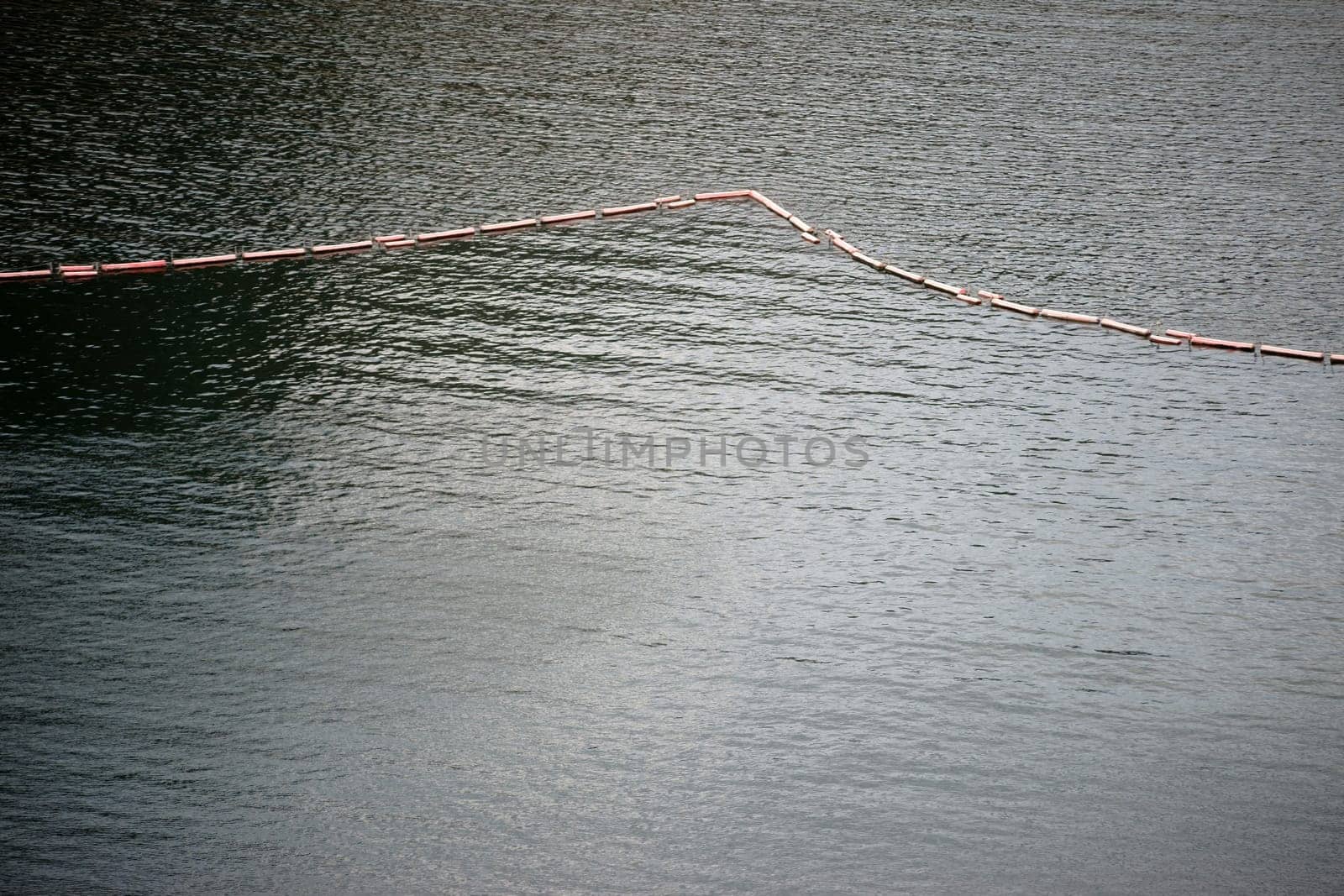 A chain of floating buoys serves as a barrier or demarcation.