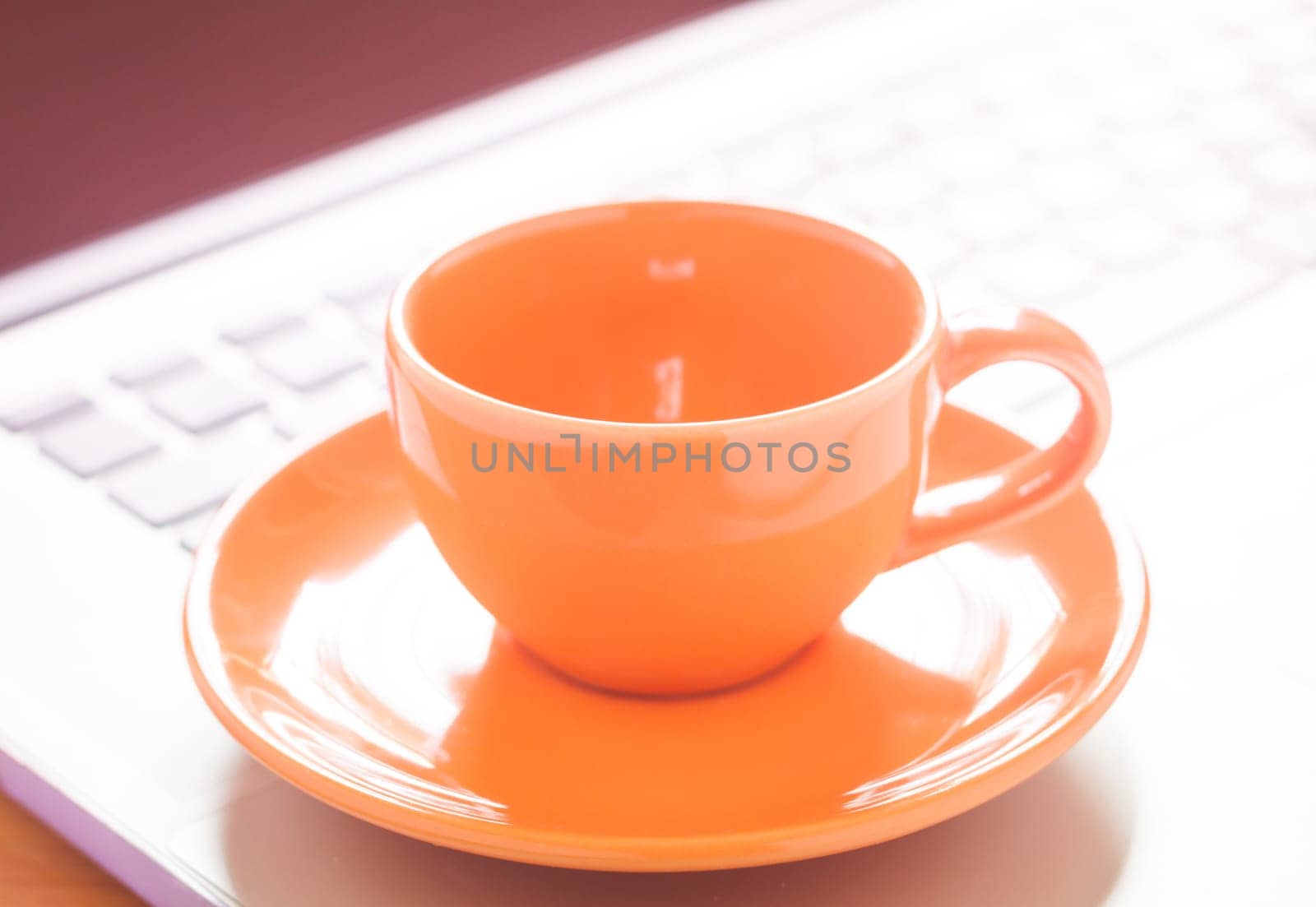 Closeup coffee cup on laptop, stock photo