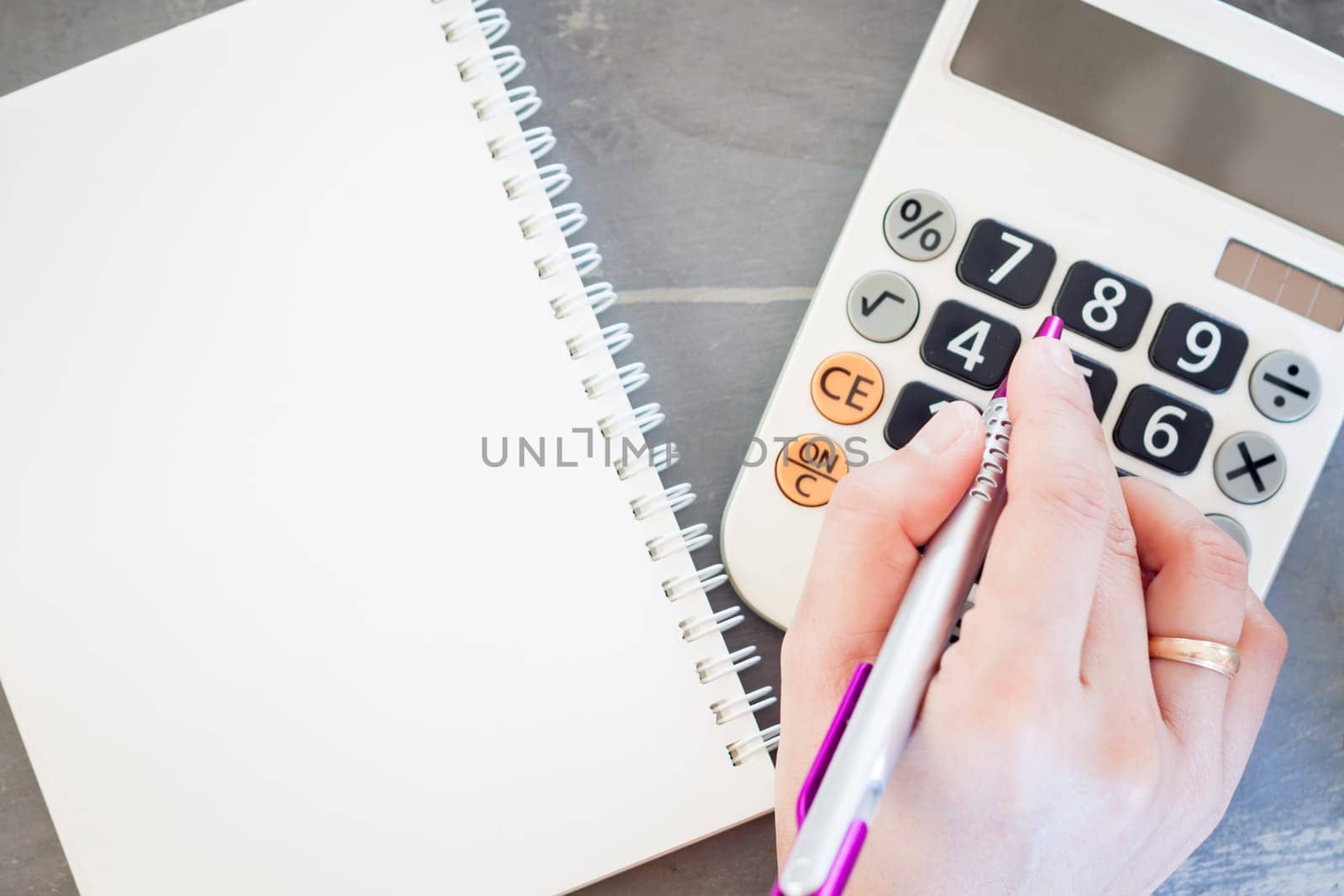 Hand with calculator and notepad, stock photo