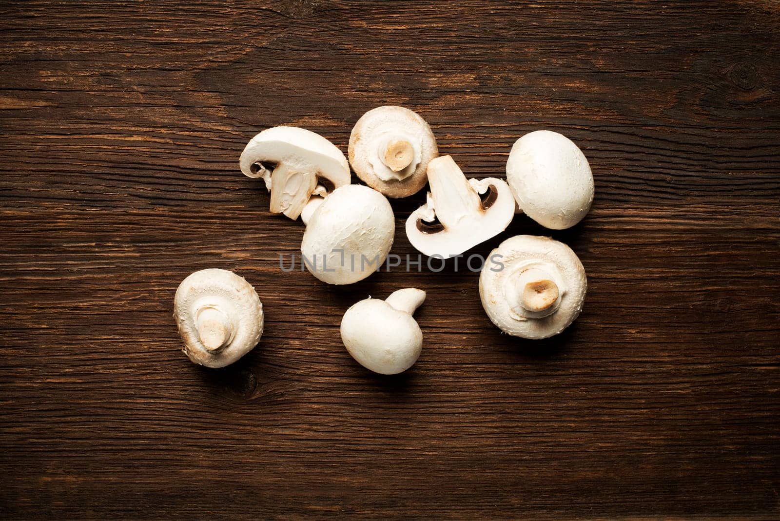 Fresh mushrooms champignons on a wooden background.