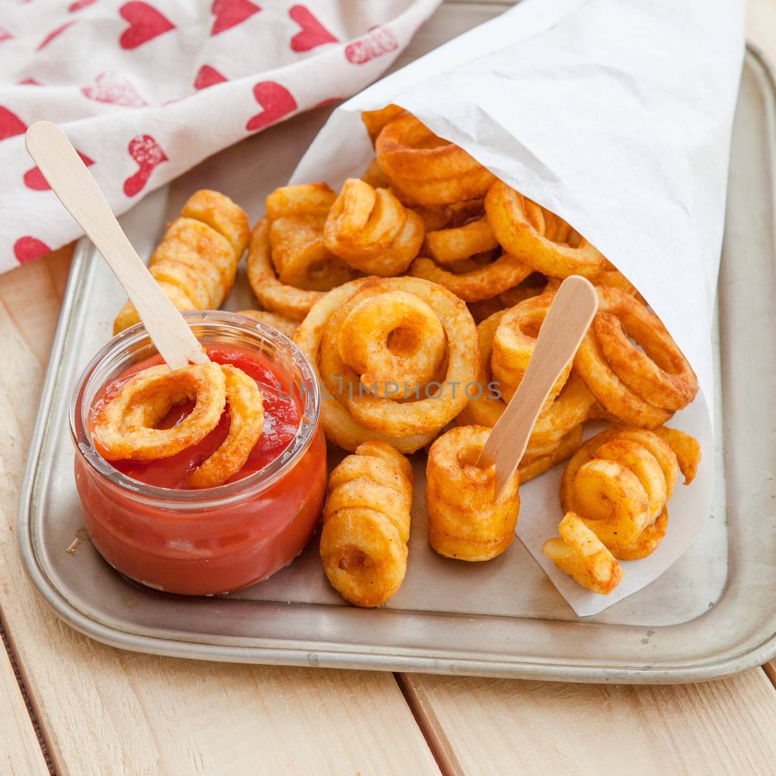 Twisted fries in paper tuete with ketchup