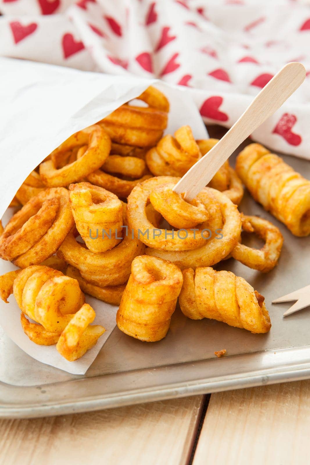 Twisted fries in paper tuete with wood pies