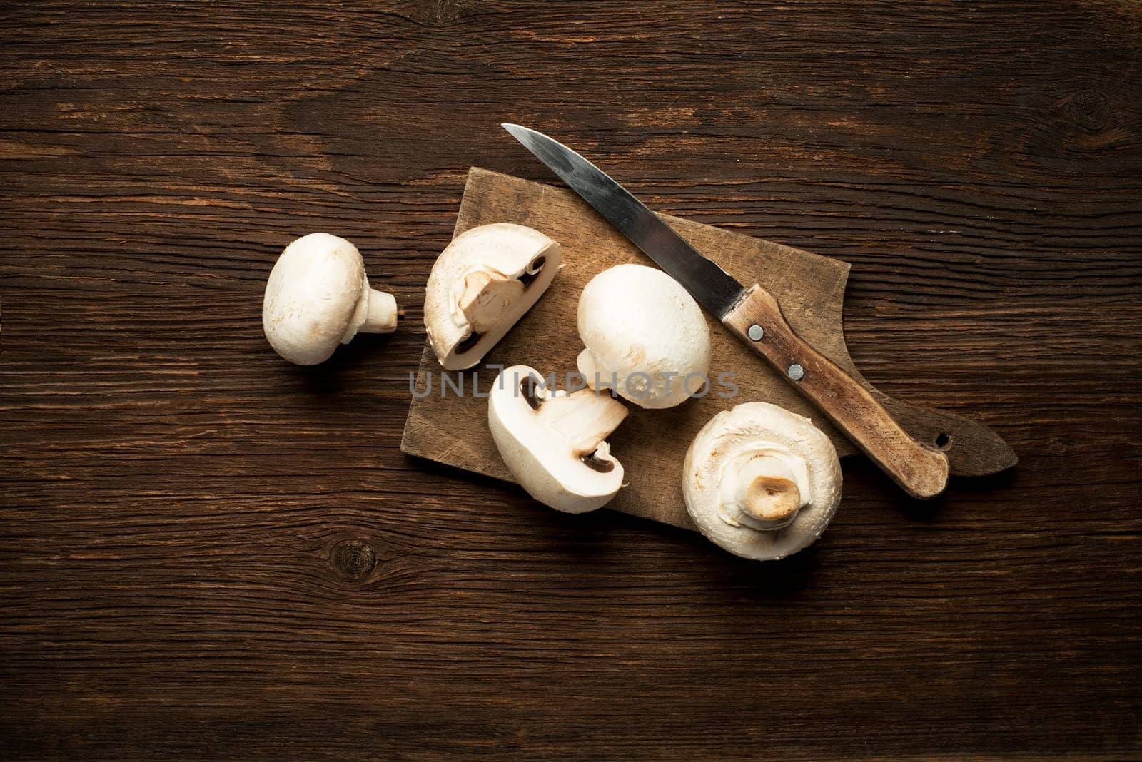 Fresh mushrooms champignons on a wooden background.
