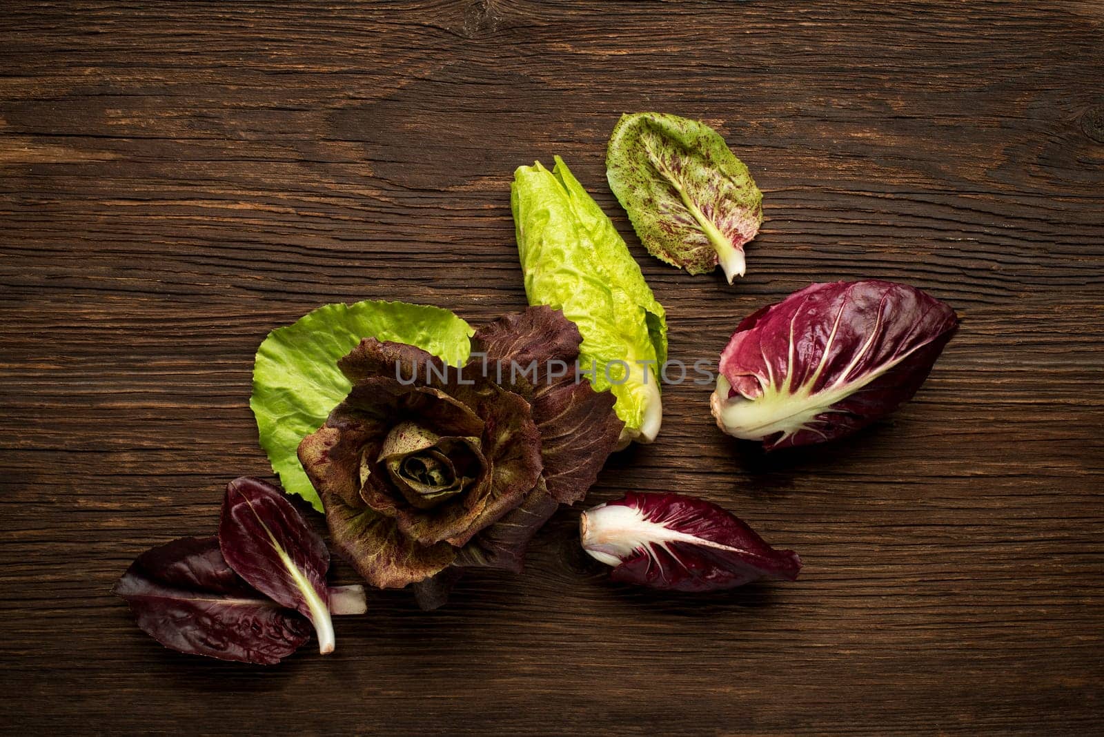 Fresh mixed radicchio on a wooden background.