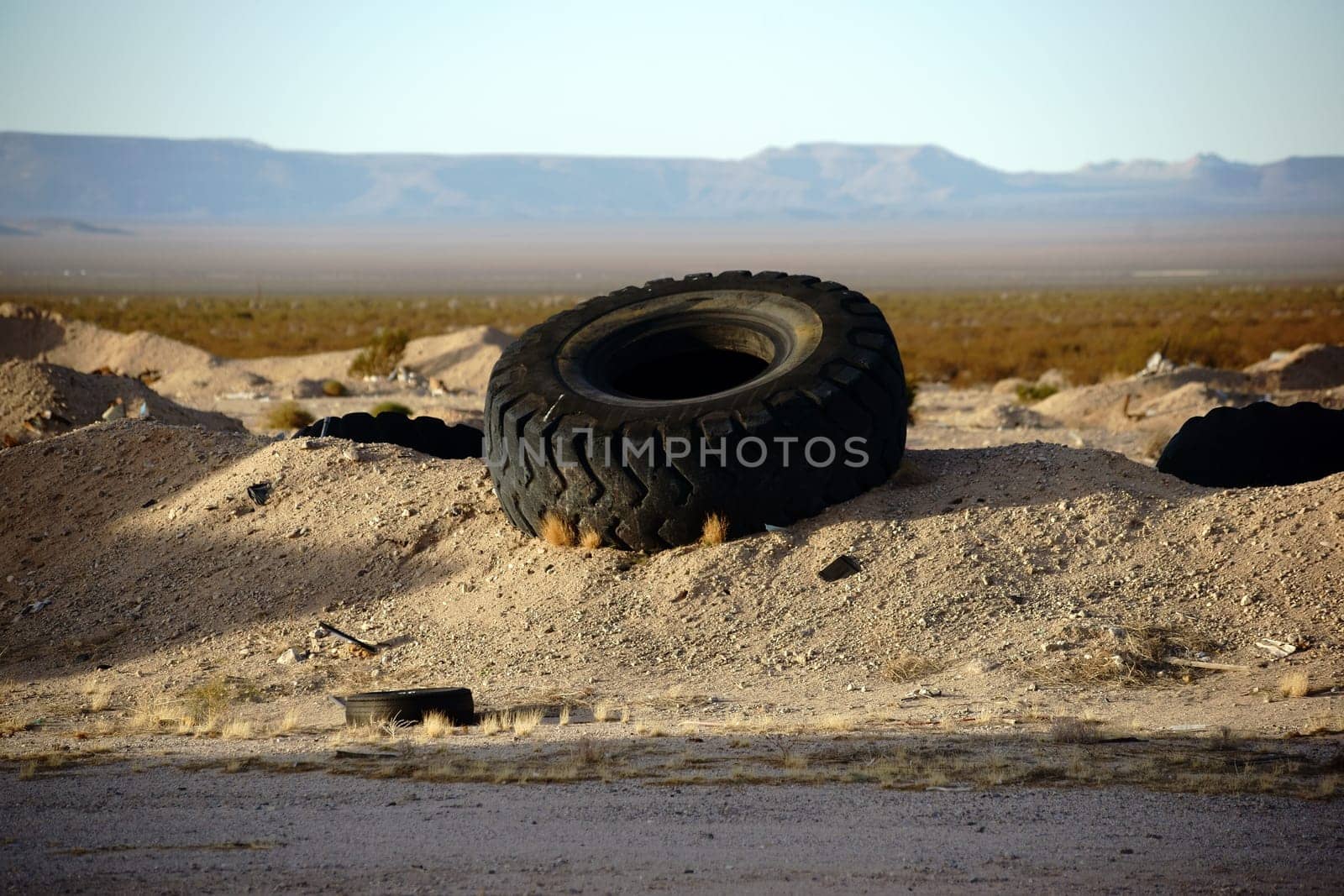 The mantle of a burst truck tire on a gravel bed on Route 66.