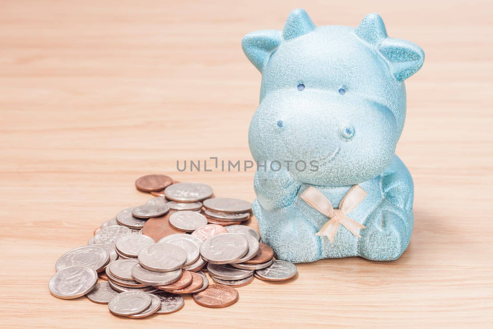 Green cow doll saving box with coins, stock photo