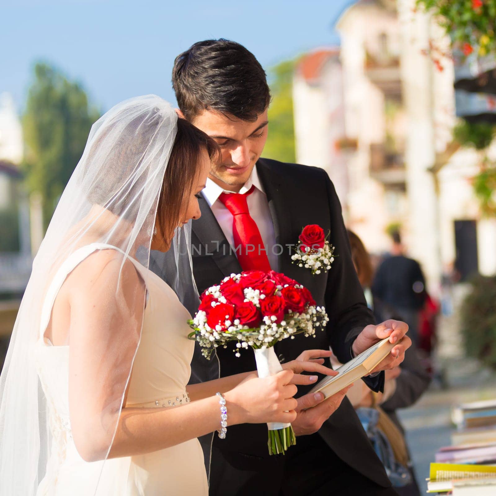 Bride and groom. Portrait of a loving wedding couple reviewing vintage books in antique book shop in medieval city center of Ljubljana, Slovenia.