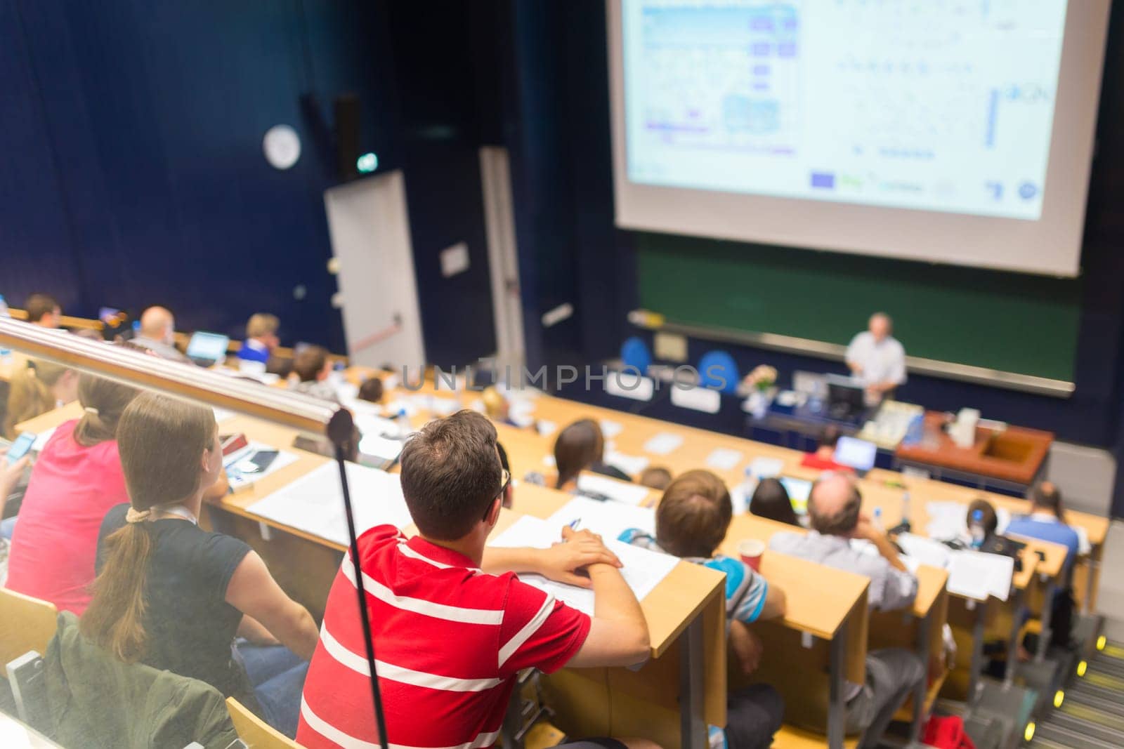 Conference and Presentation. Audience at the conference hall. Business and Entrepreneurship. Faculty lecture and workshop. Audience in the lecture hall. Academic education. Students making notes.