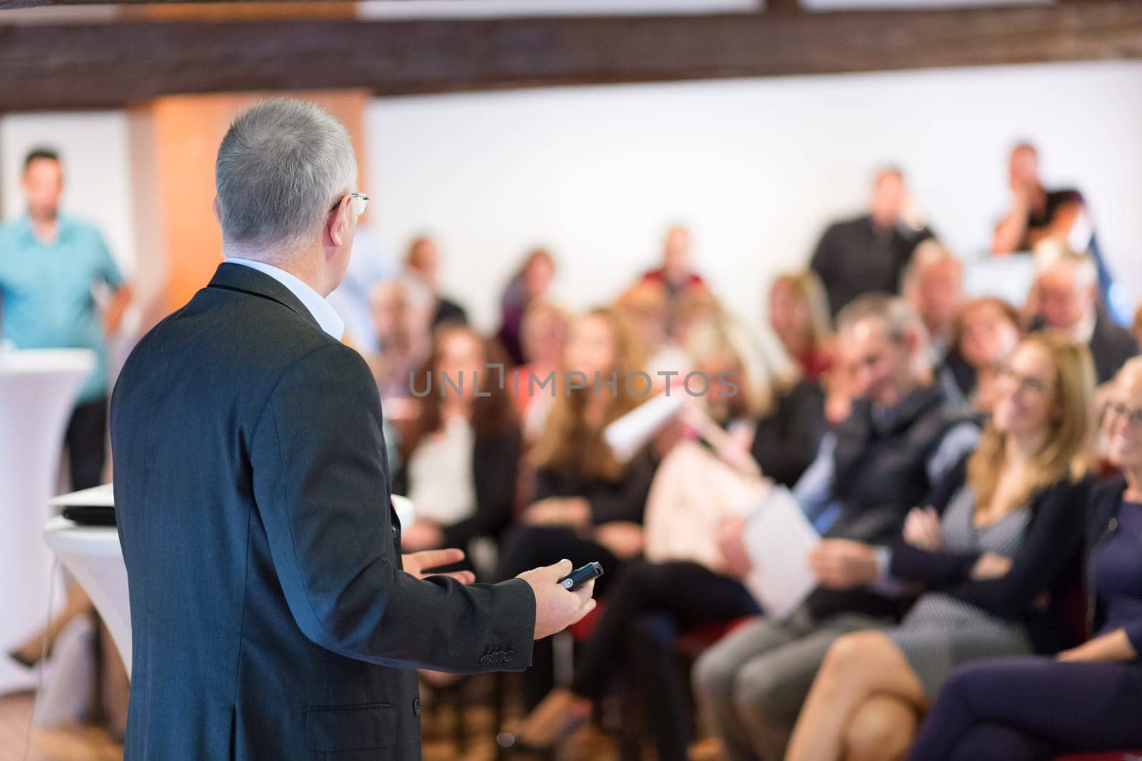 Speaker at Business Conference with Public Presentations. Audience at the conference hall. Entrepreneurship club. Rear view. Horisontal composition. Background blur.
