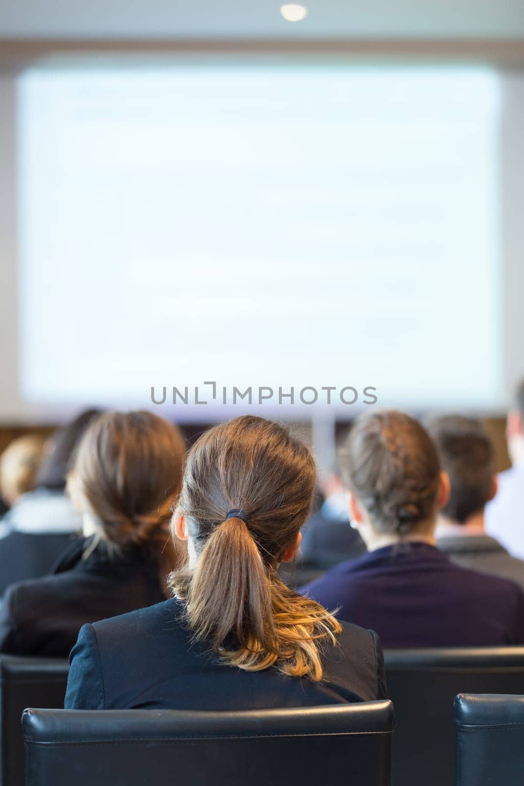 Speaker Giving a Talk at Business Meeting. Audience in the conference hall. Business and Entrepreneurship. Vertical composition. Copy space.