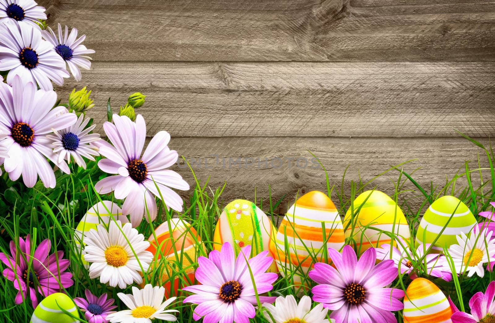 Spring flowers and happy colorful Easter eggs with rustic wood planks in the background