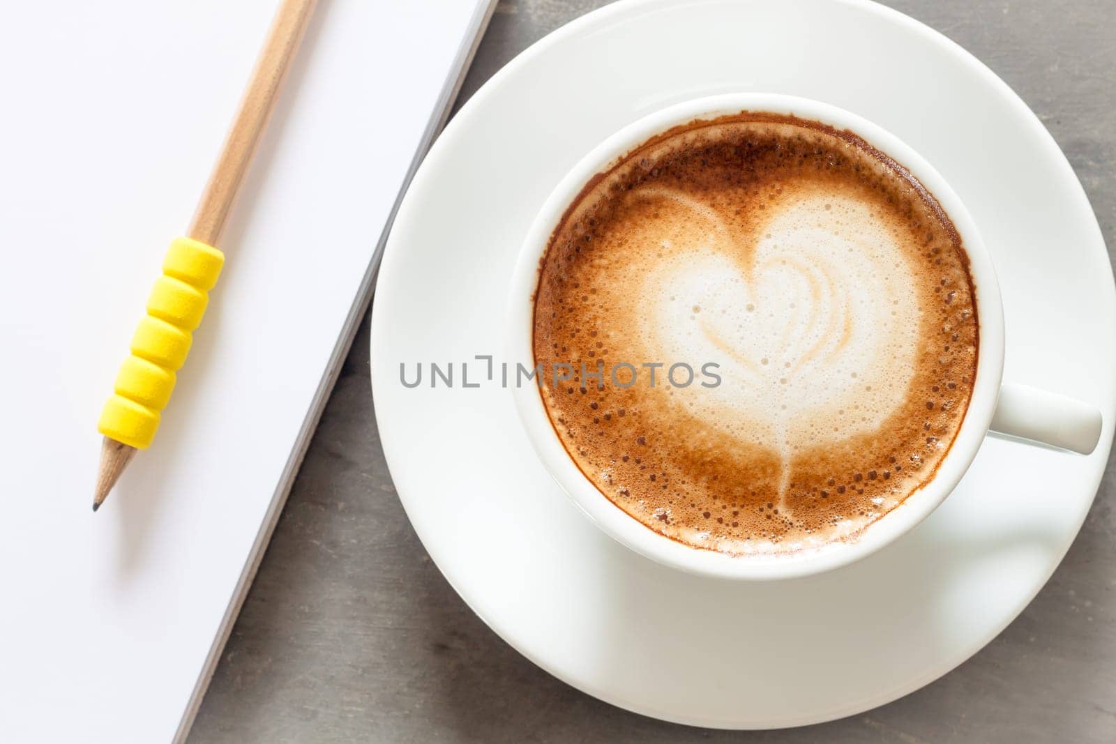 Coffee cup with notepad on grey background, stock photo