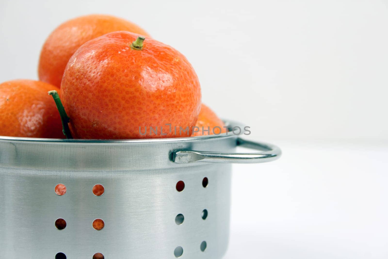 Mandarins in kitchen sieves