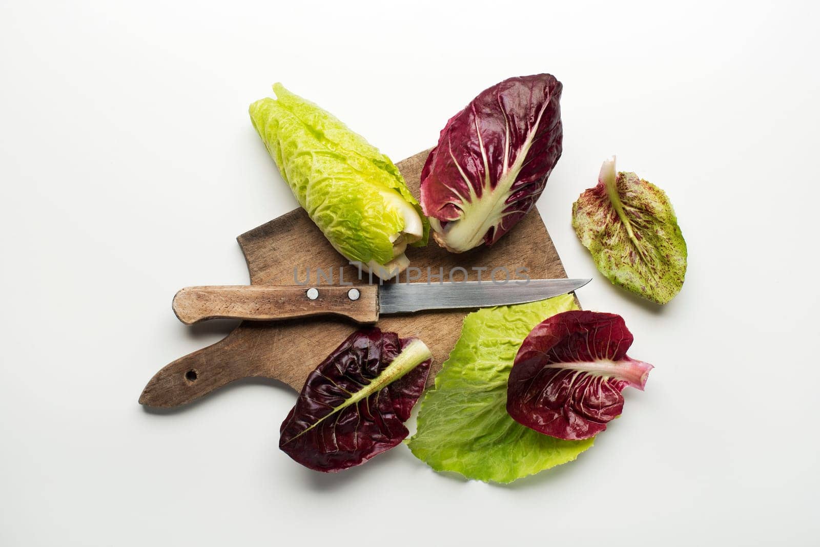 Fresh mixed salad leaves with radicchio on a white background.