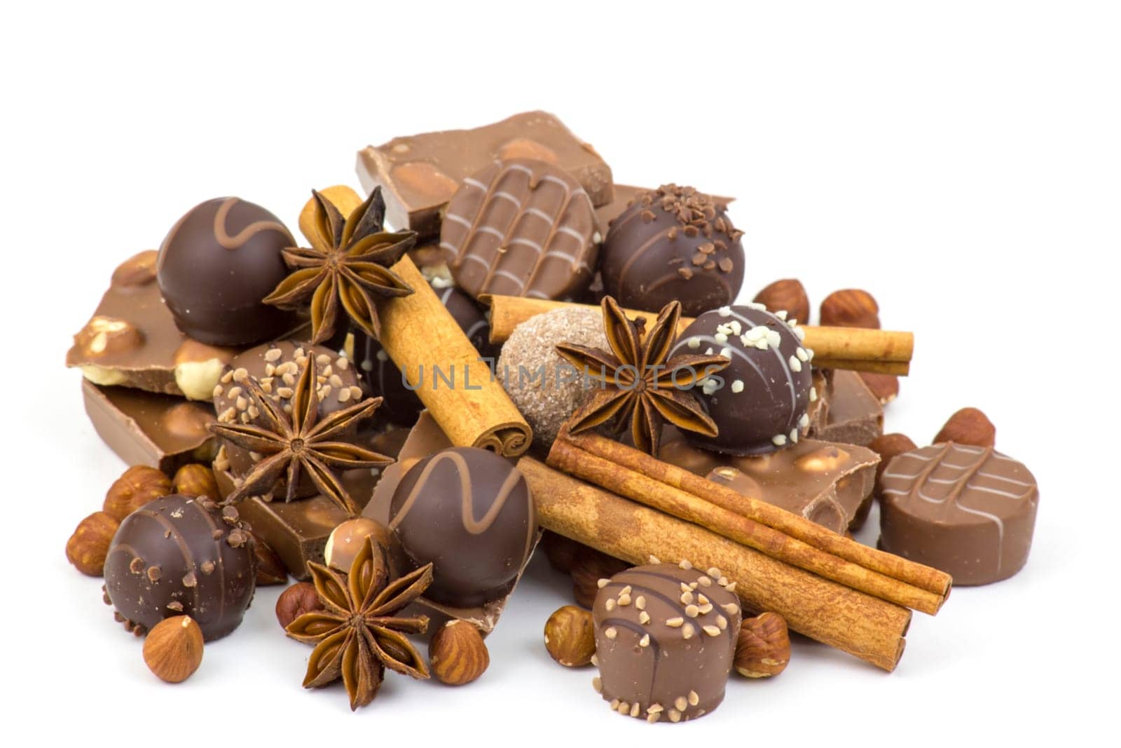 chocolate, spices and nuts on white background