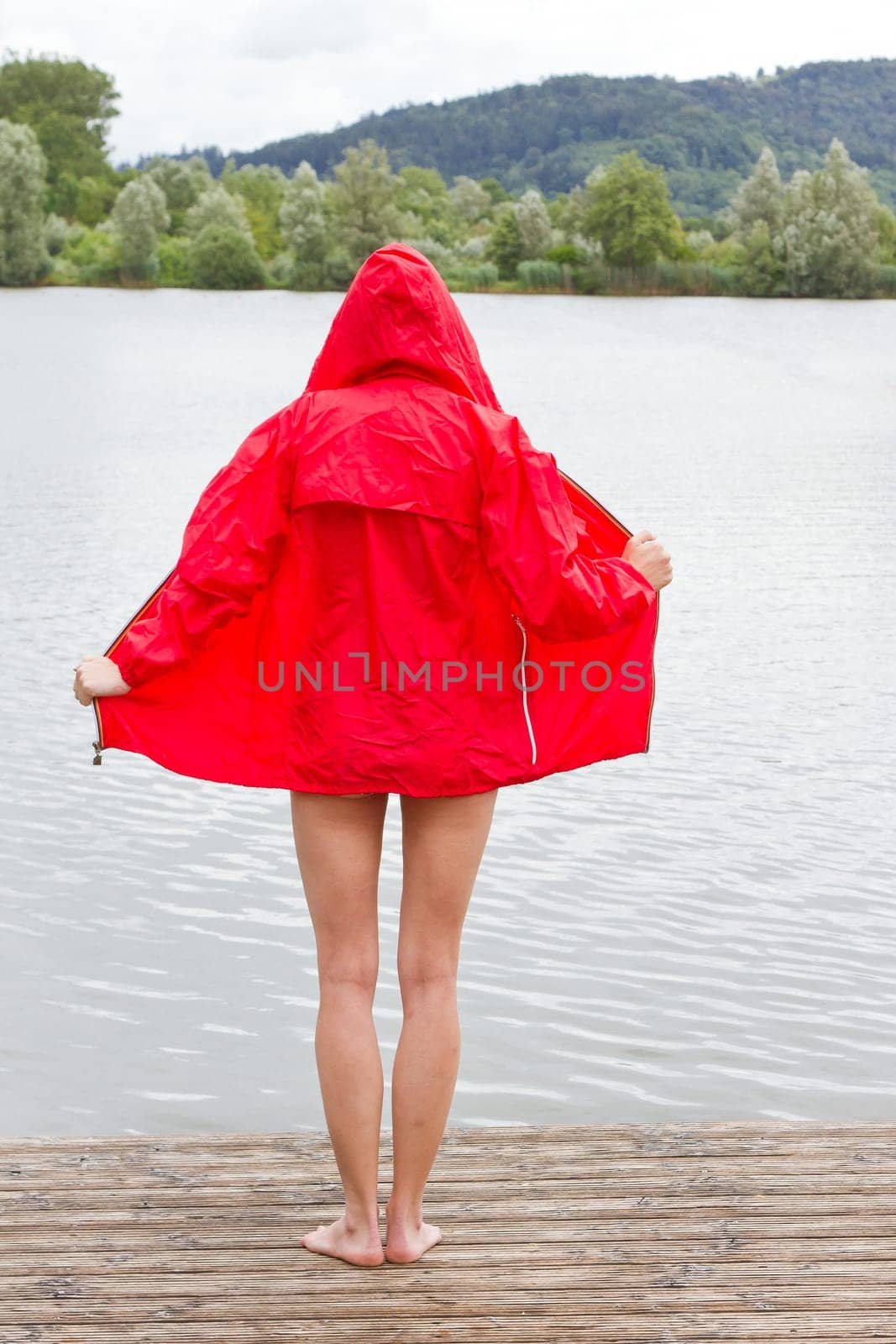 Young woman in red jacket at the lake
