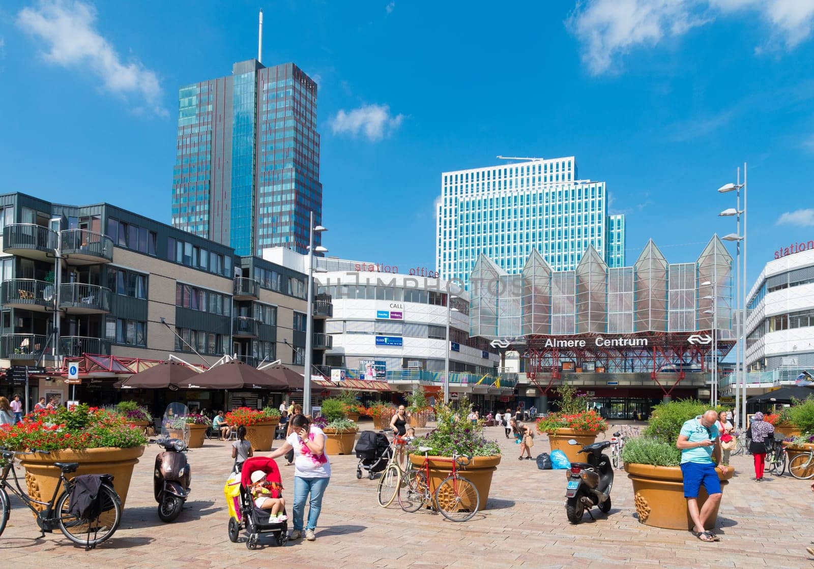 Central train station in Almere, Netherlands on a sunday shopping day. The station opened may 1987 and is designed by Peter Kilsdonk. Under the station lies a bus station