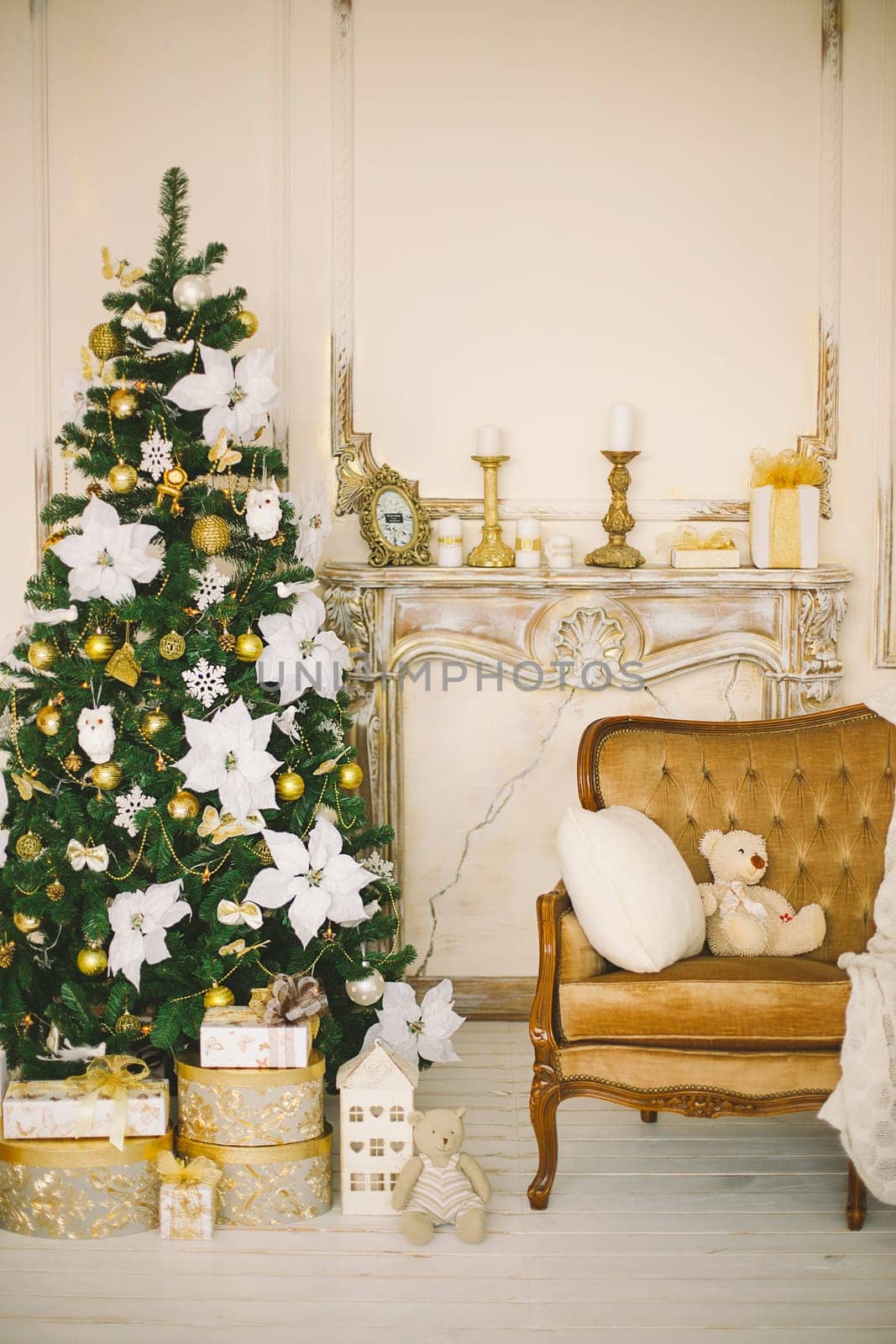 New Year's and Christmas interior in gold color with a chimney portal, a fir-tree and gifts