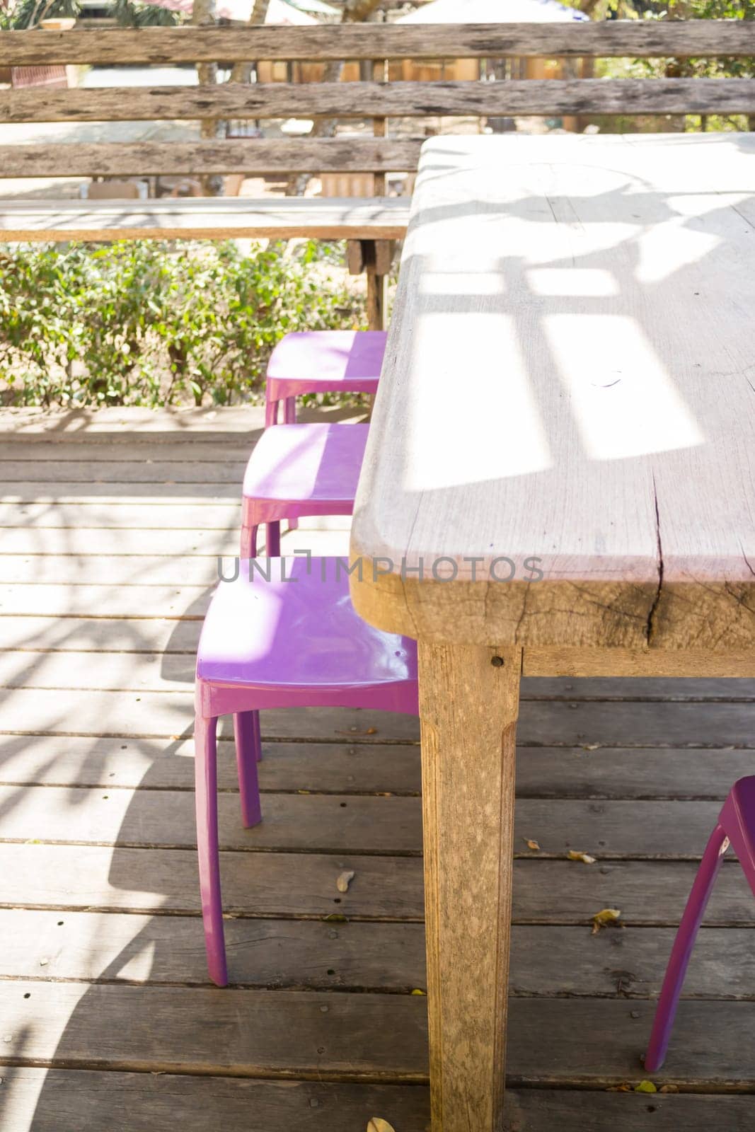 Table and chairs standing in the garden with shadows, stock photo
