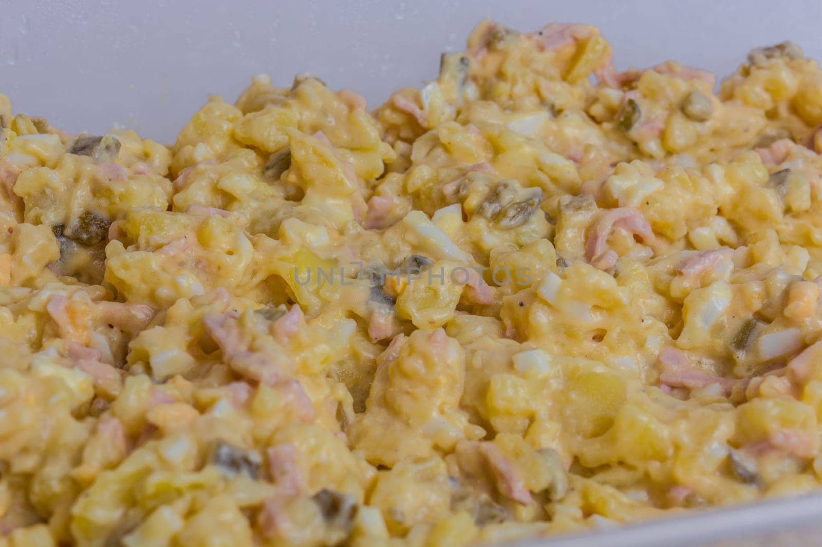 Homemade potato salad with eggs and cucumbers.