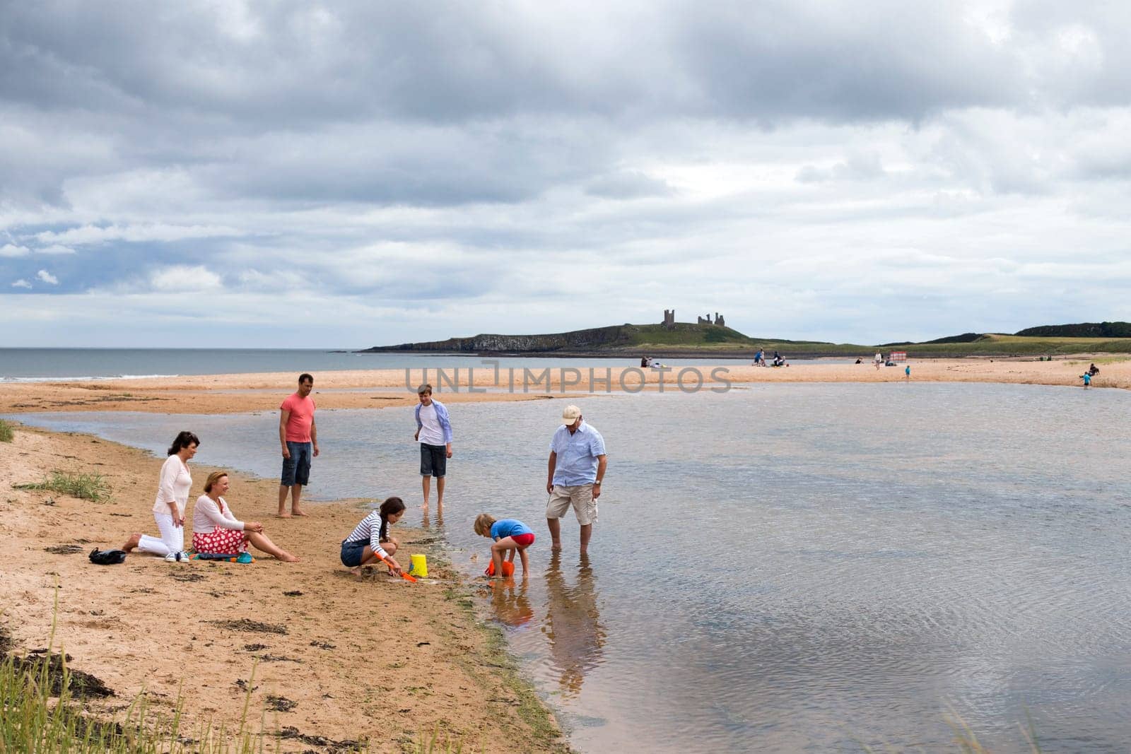 A family are playing together on the beach and in the sea.