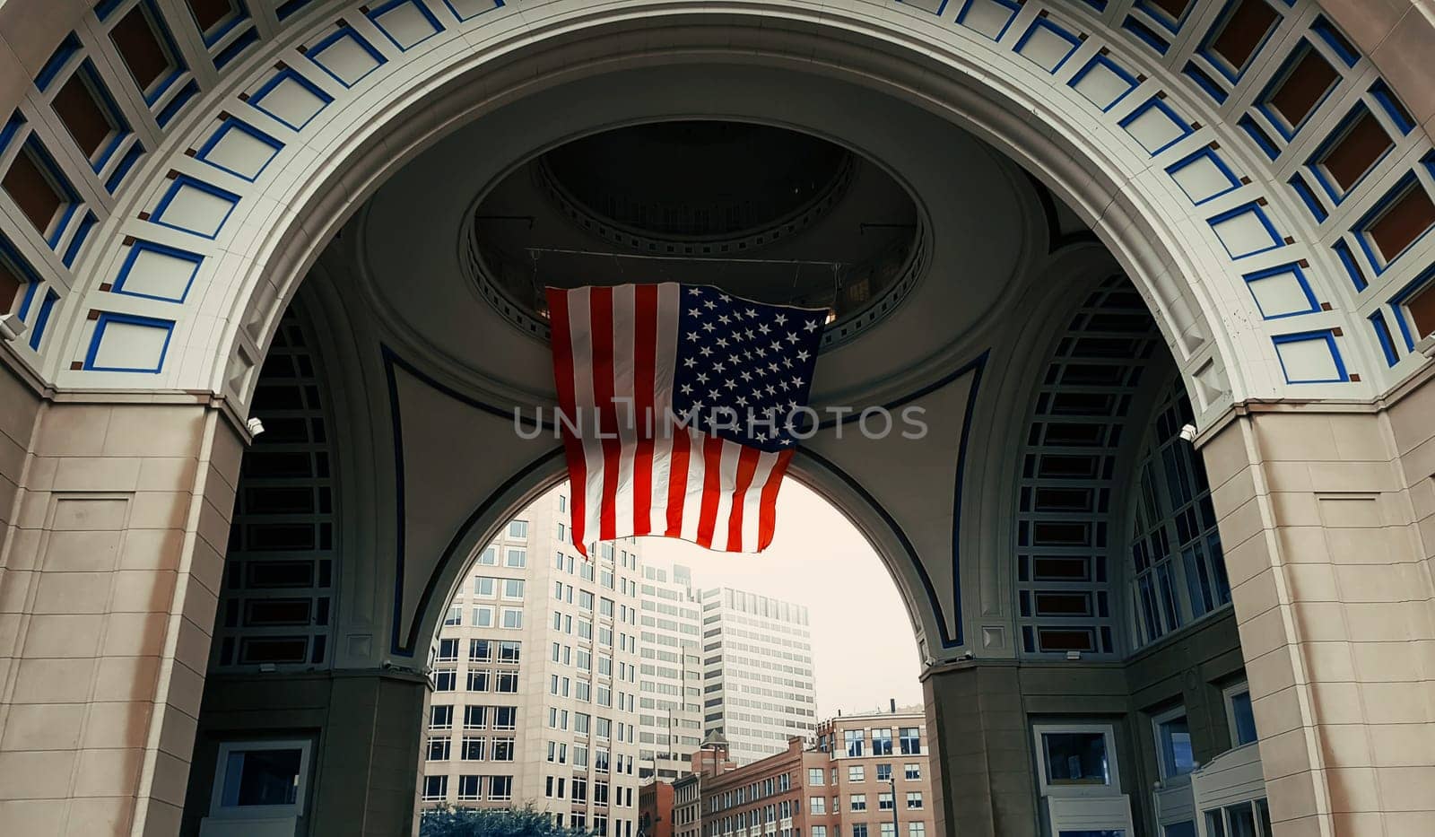 Looking through the arch at Rowes Wharf, in Boston, Massachusetts. USA flag hoisted