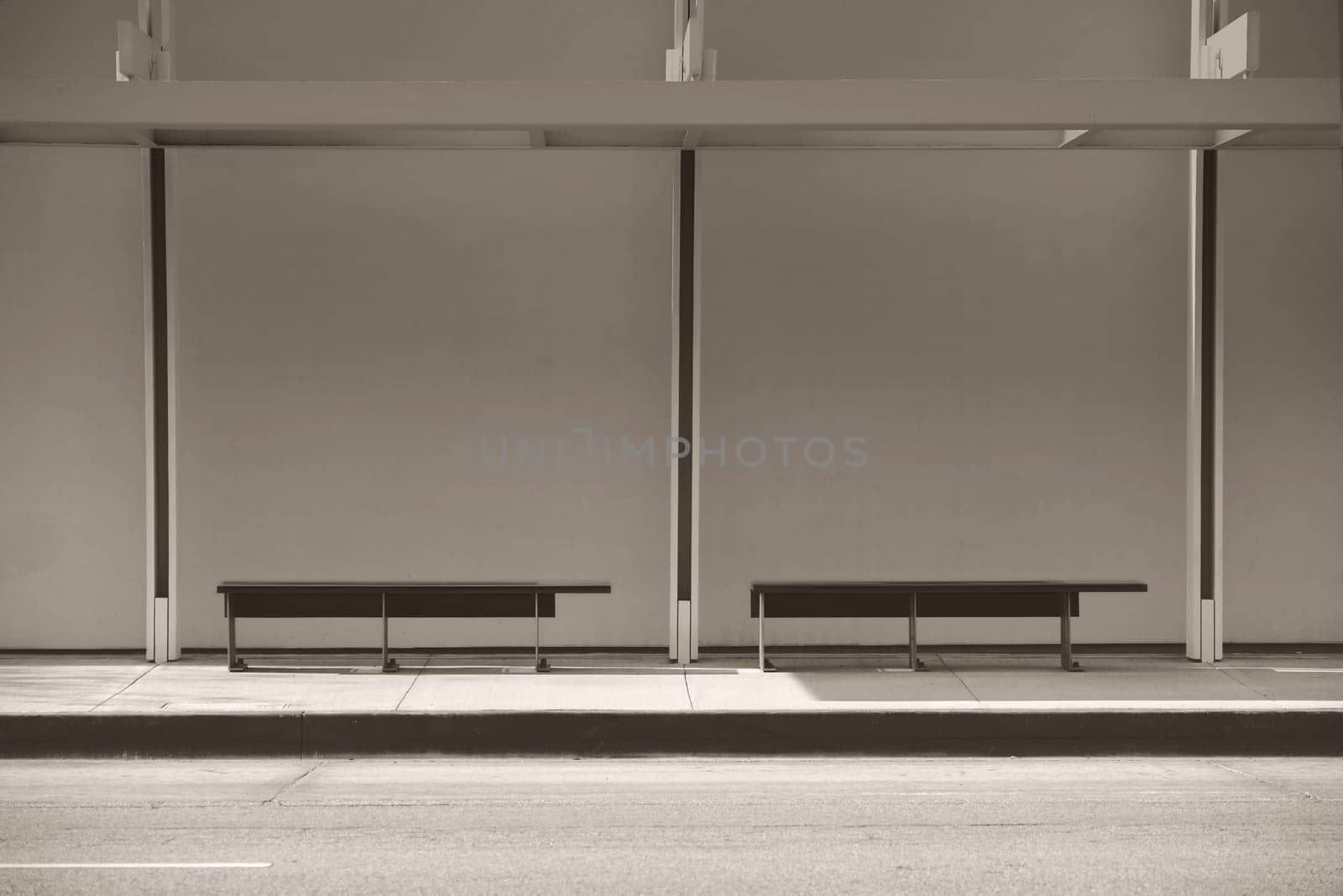A modern bus stop with a canopy and benches.