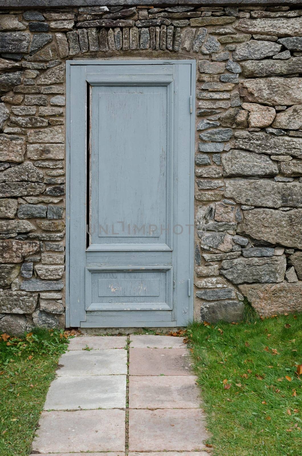 one old and grey door in the stone wall at Gunnebo castle