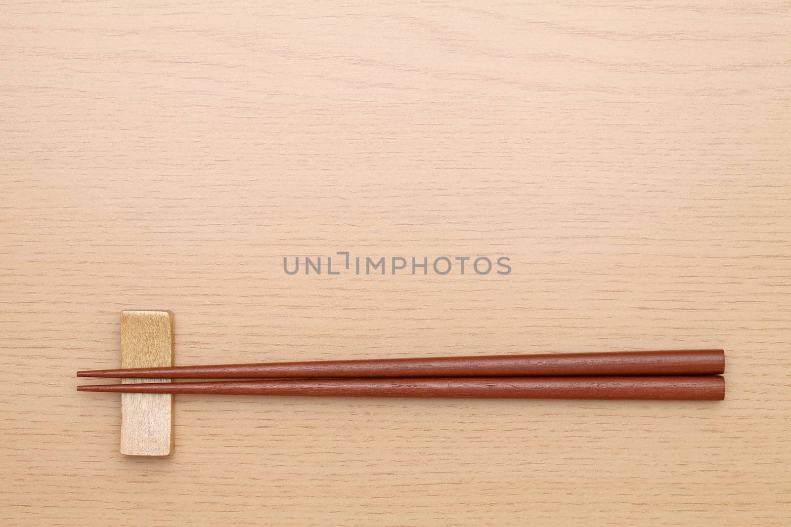 chopsticks and chopsticks rest on wooden table