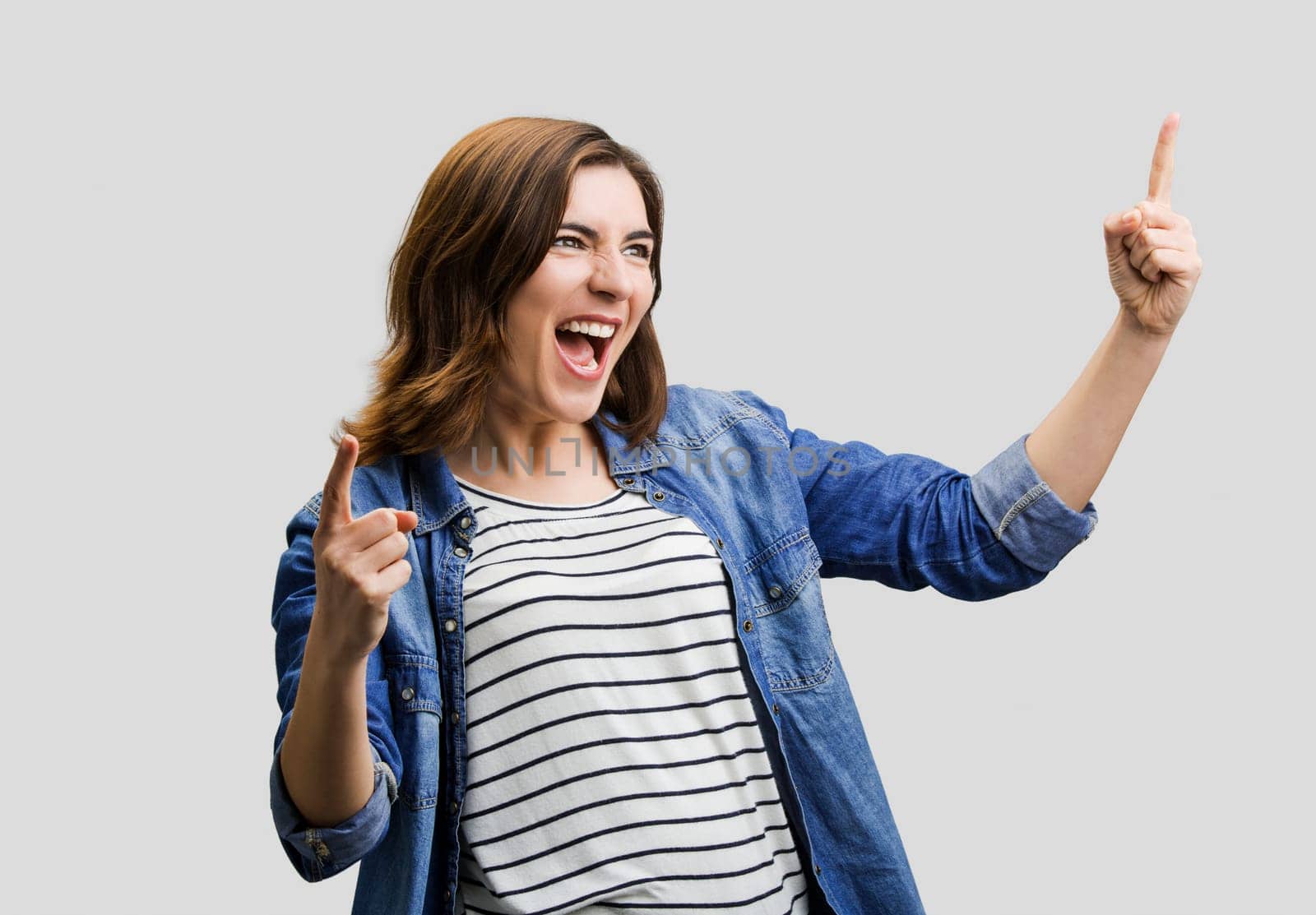 Studio portrait of a happy woman with arms raised