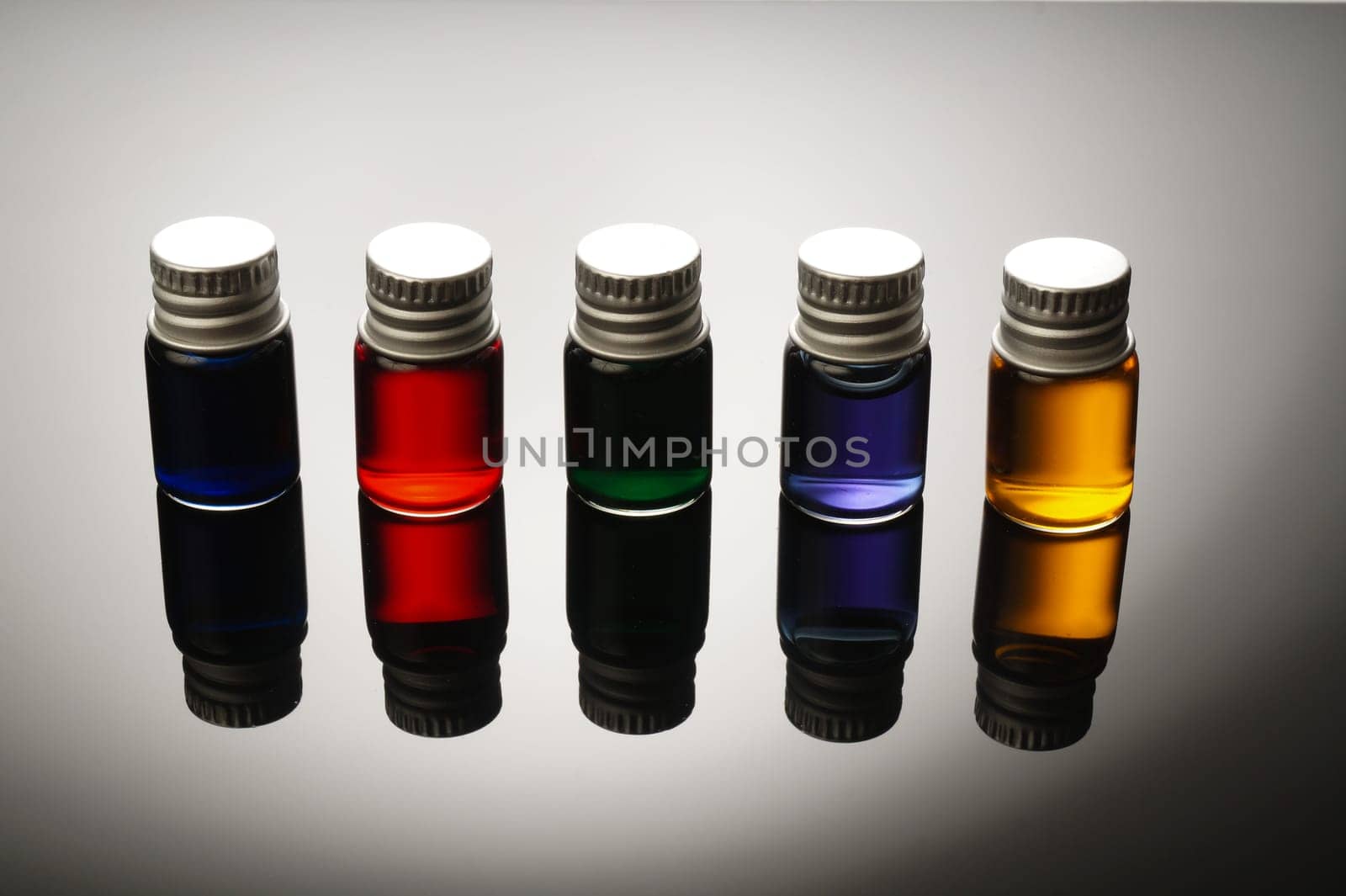 Five Colorful vials isolated on black background