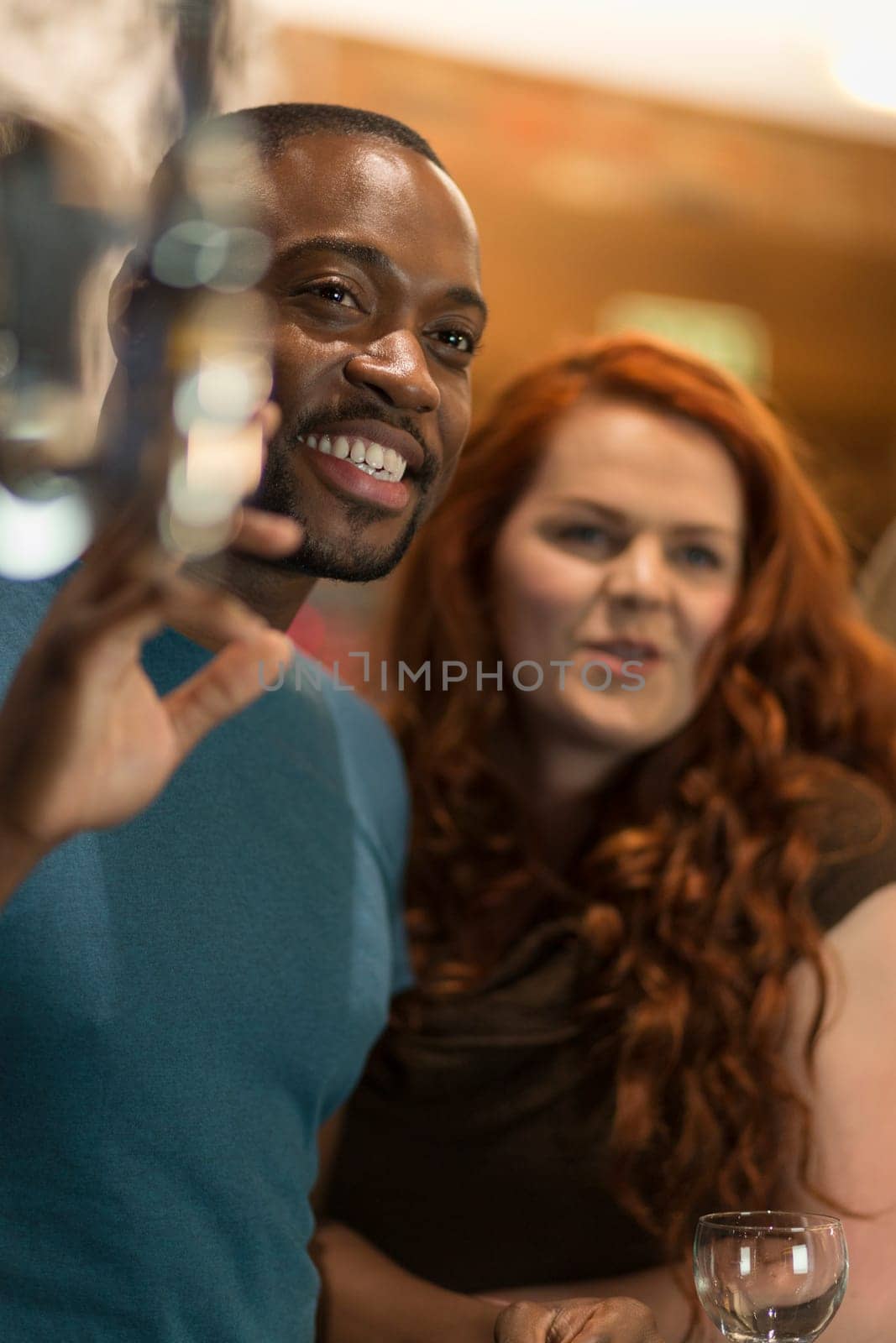 Young man waving to someone in a bar