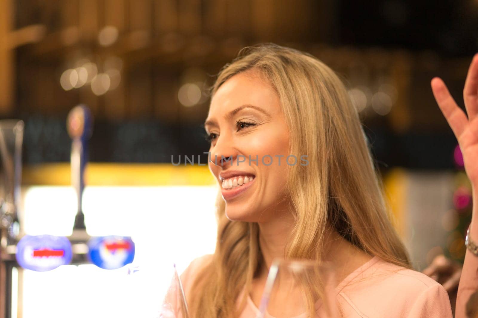 close up shot of a woman talking to her friends at a bar.