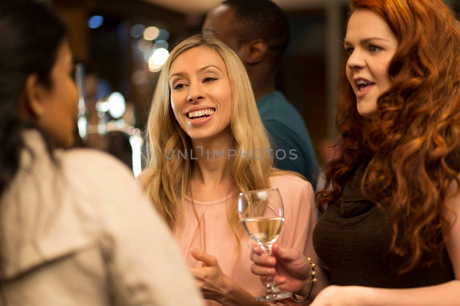 close up shot of a woman talking to her friends at a bar.
