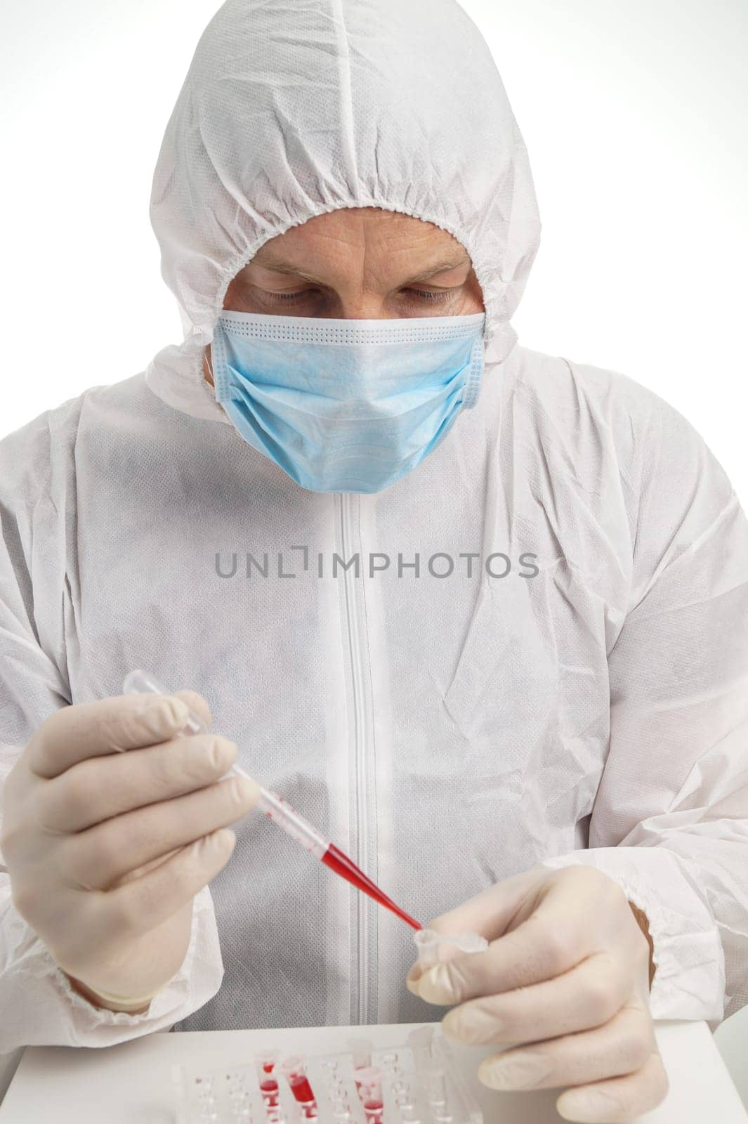 Man testing lab sample in protective suit and mask